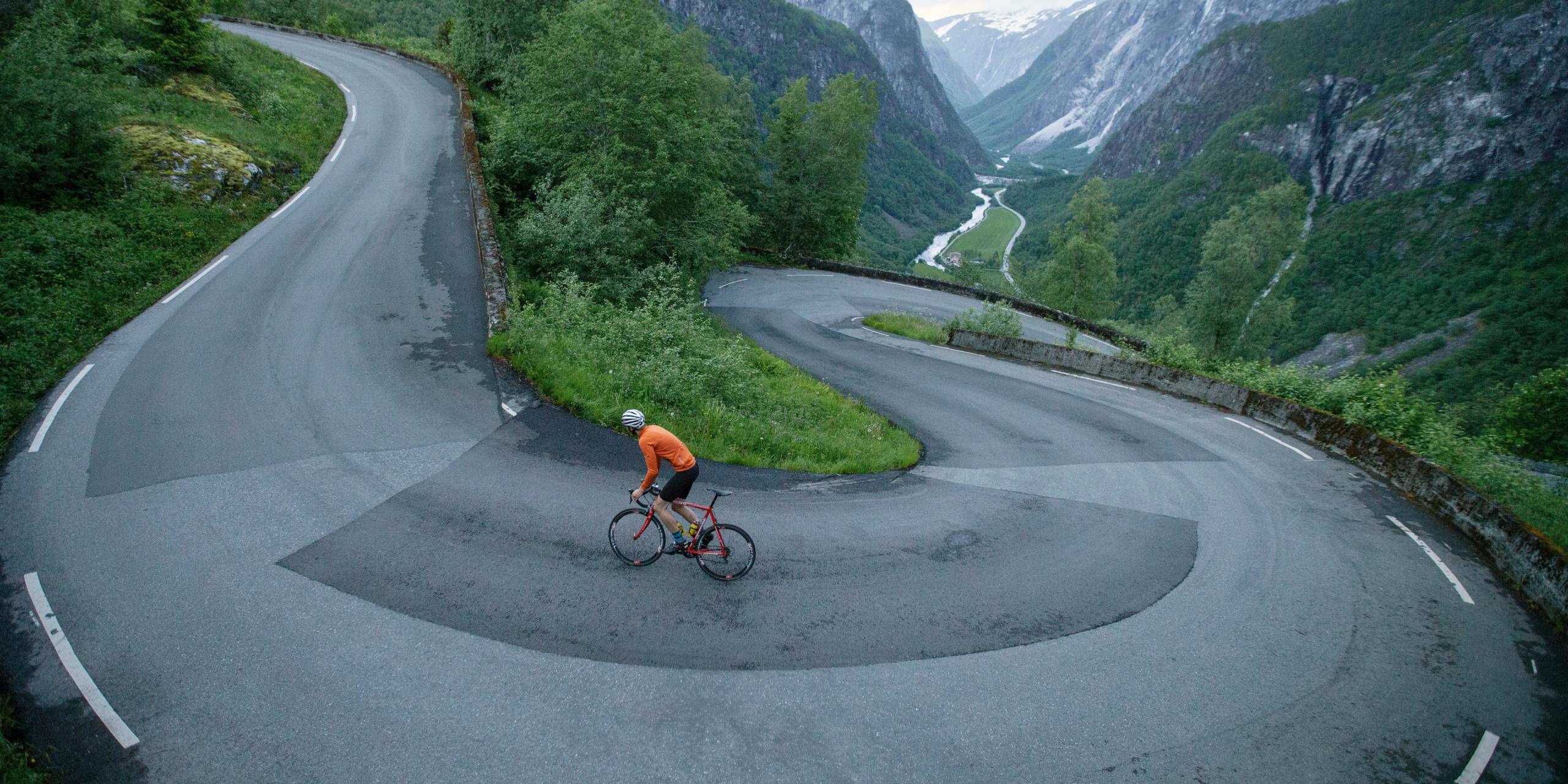 A person road cycling up Stalheimskleiva in Voss in Fjord Norway, one of Norway’s toughest uphill bike routes