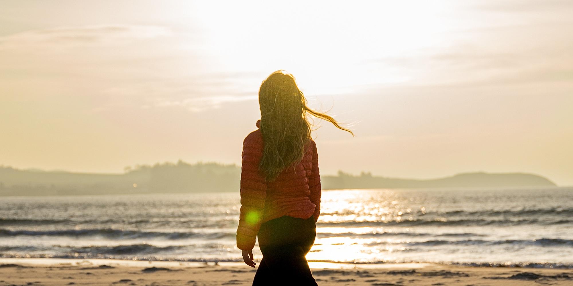 A woman enjoying the beautiful sunset at Solastranden, Sola Beach in Stavanger