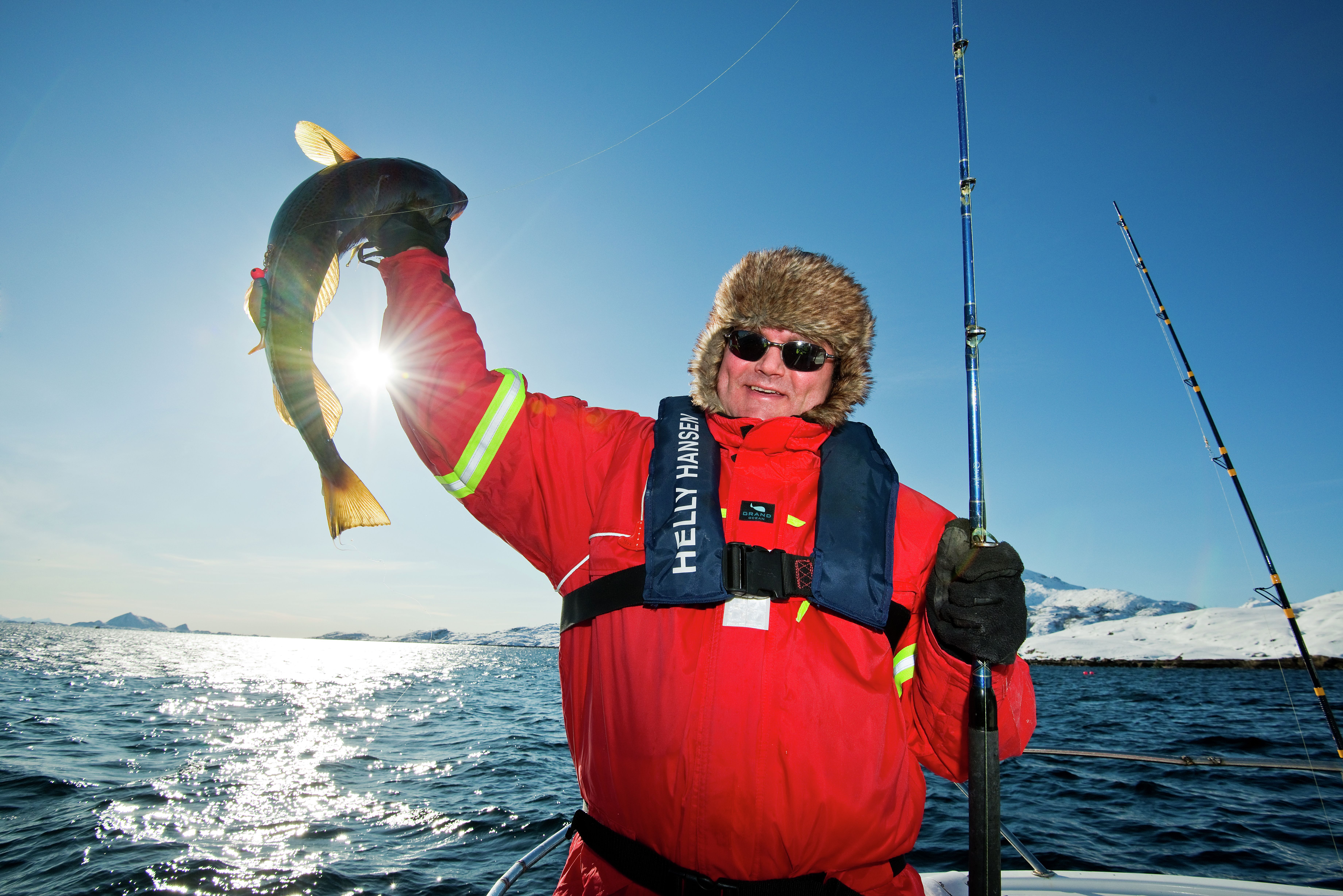 A man who has caught a fish in Austnesfjorden in Lofoten in Northern Norway