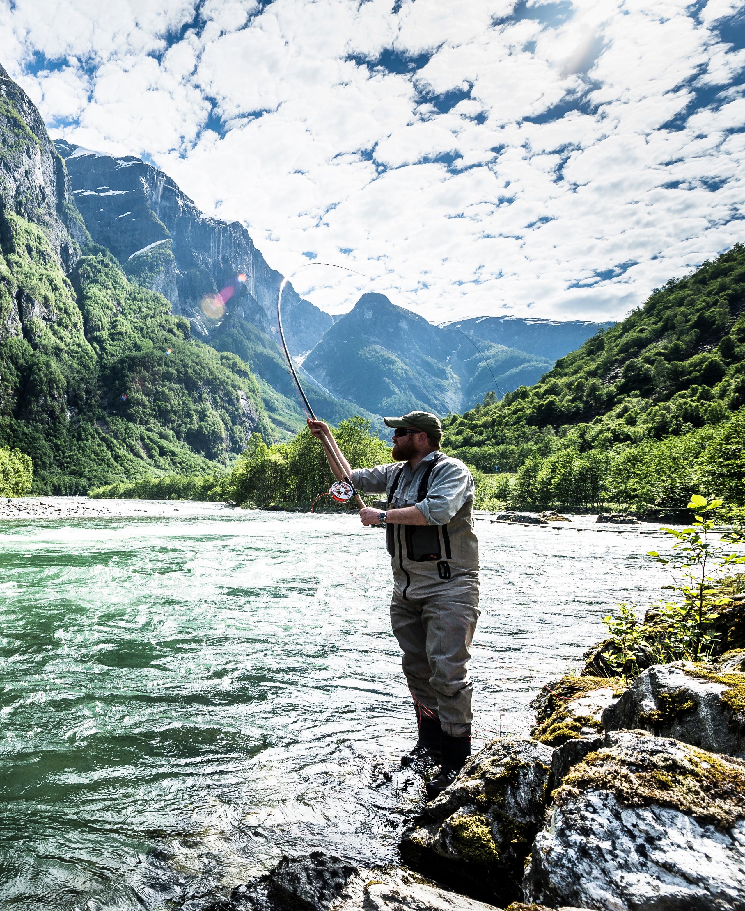 A man fishing for wild salmon in the Nærøydalselva in Fjord Norway