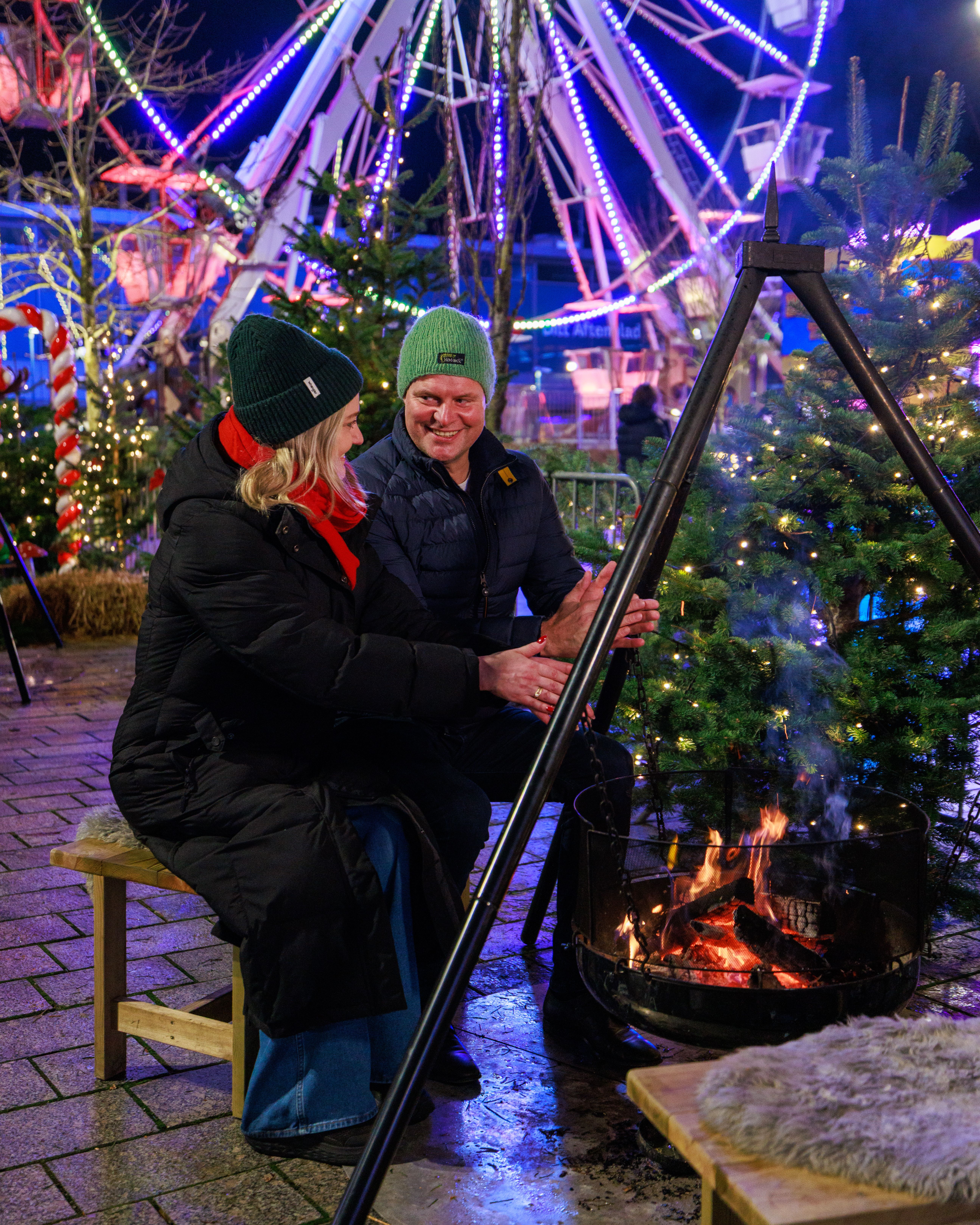 A couple warming up by the firepit at Sandnes Christmas Market, Vinterland i Sandnes