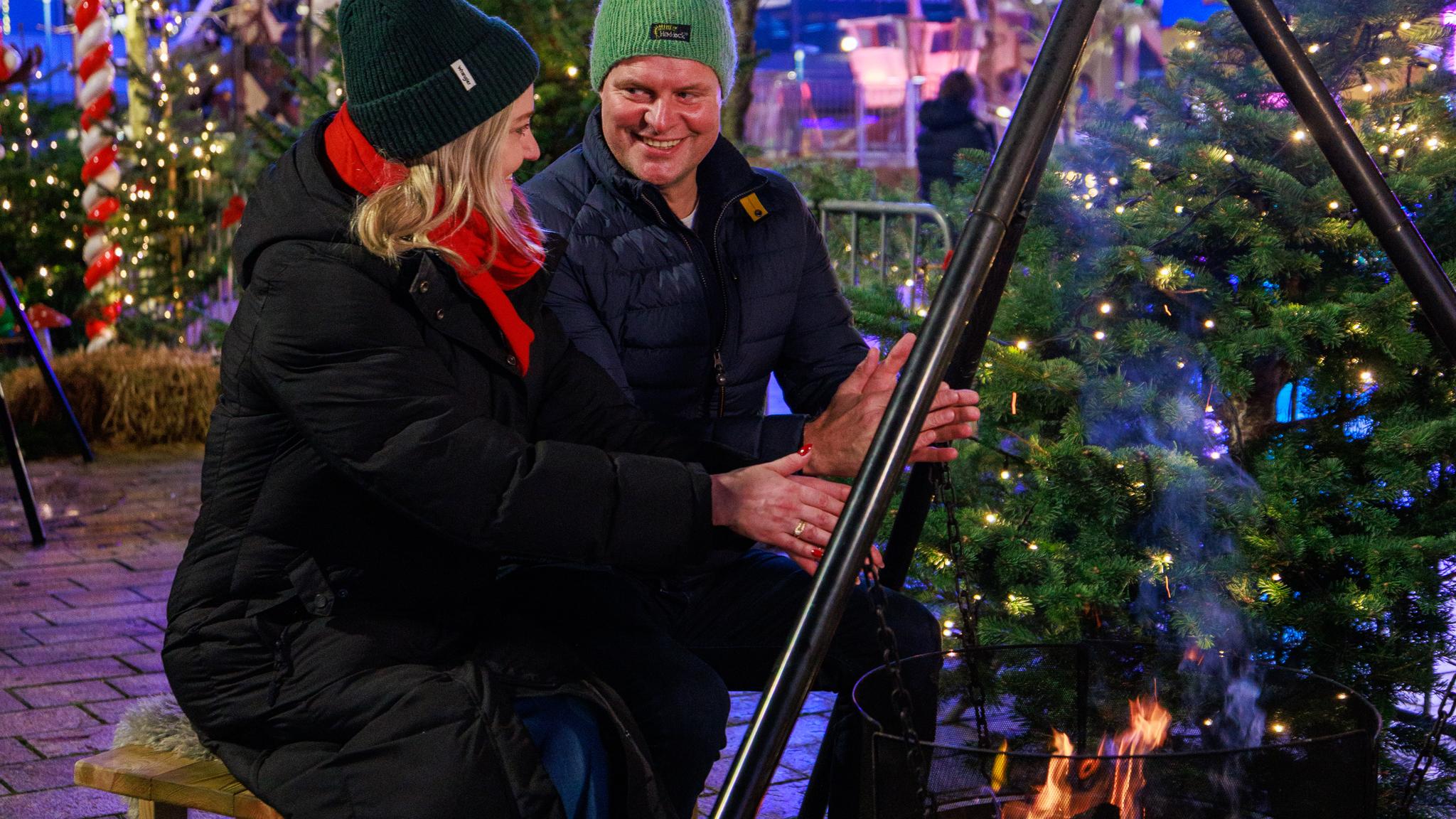 A couple warming up by the firepit at Sandnes Christmas Market, Vinterland i Sandnes