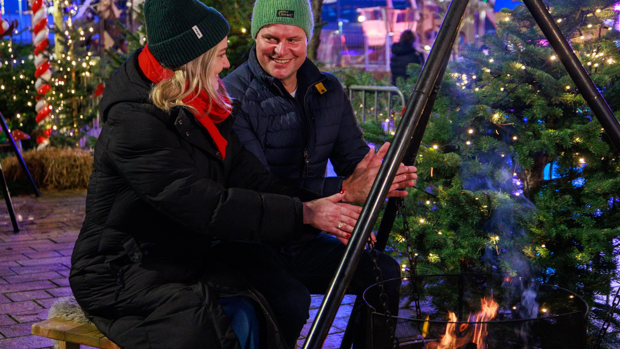 A couple warming up by the firepit at Sandnes Christmas Market, Vinterland i Sandnes
