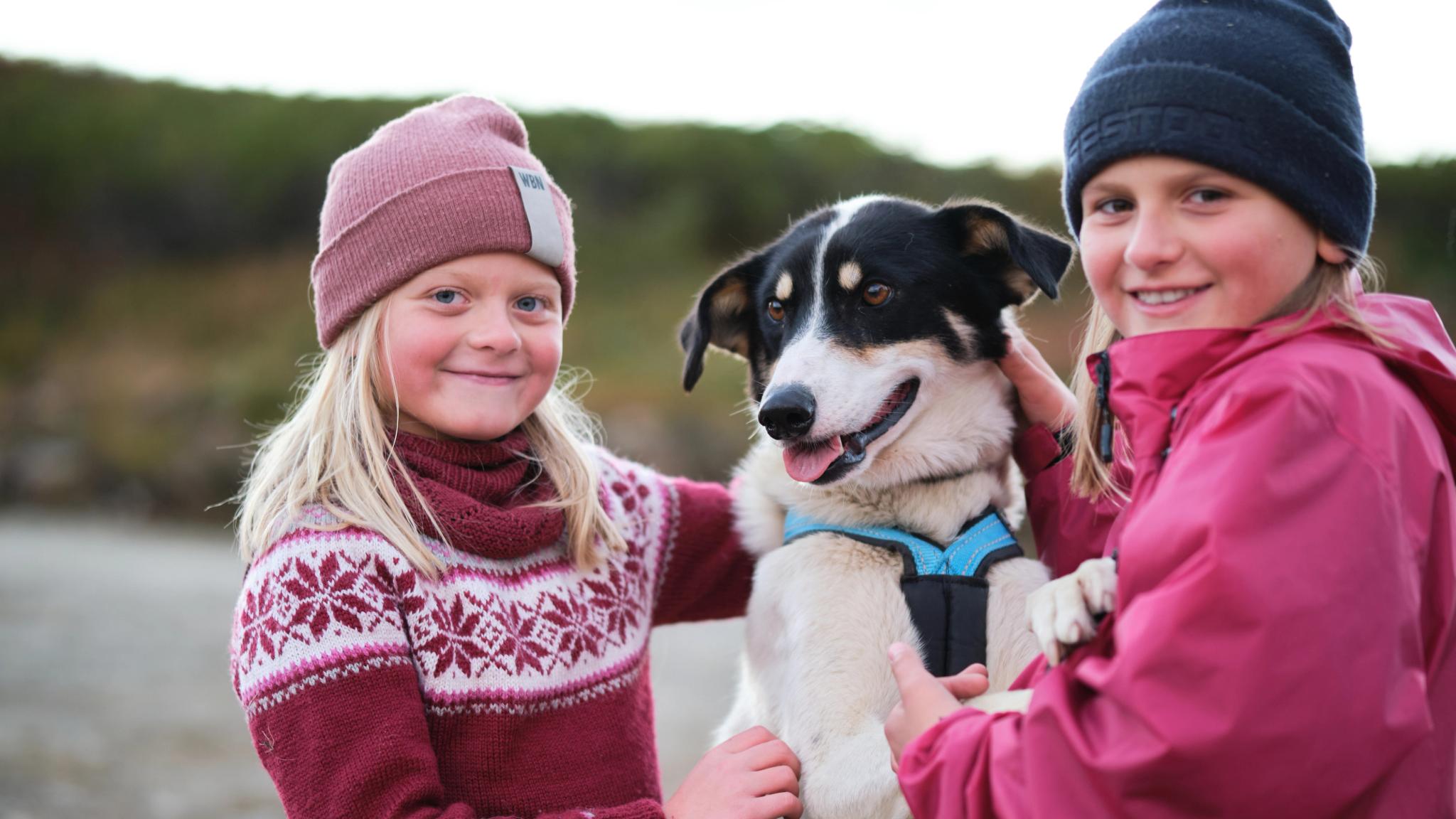 To jenter koser med en hund i Norge