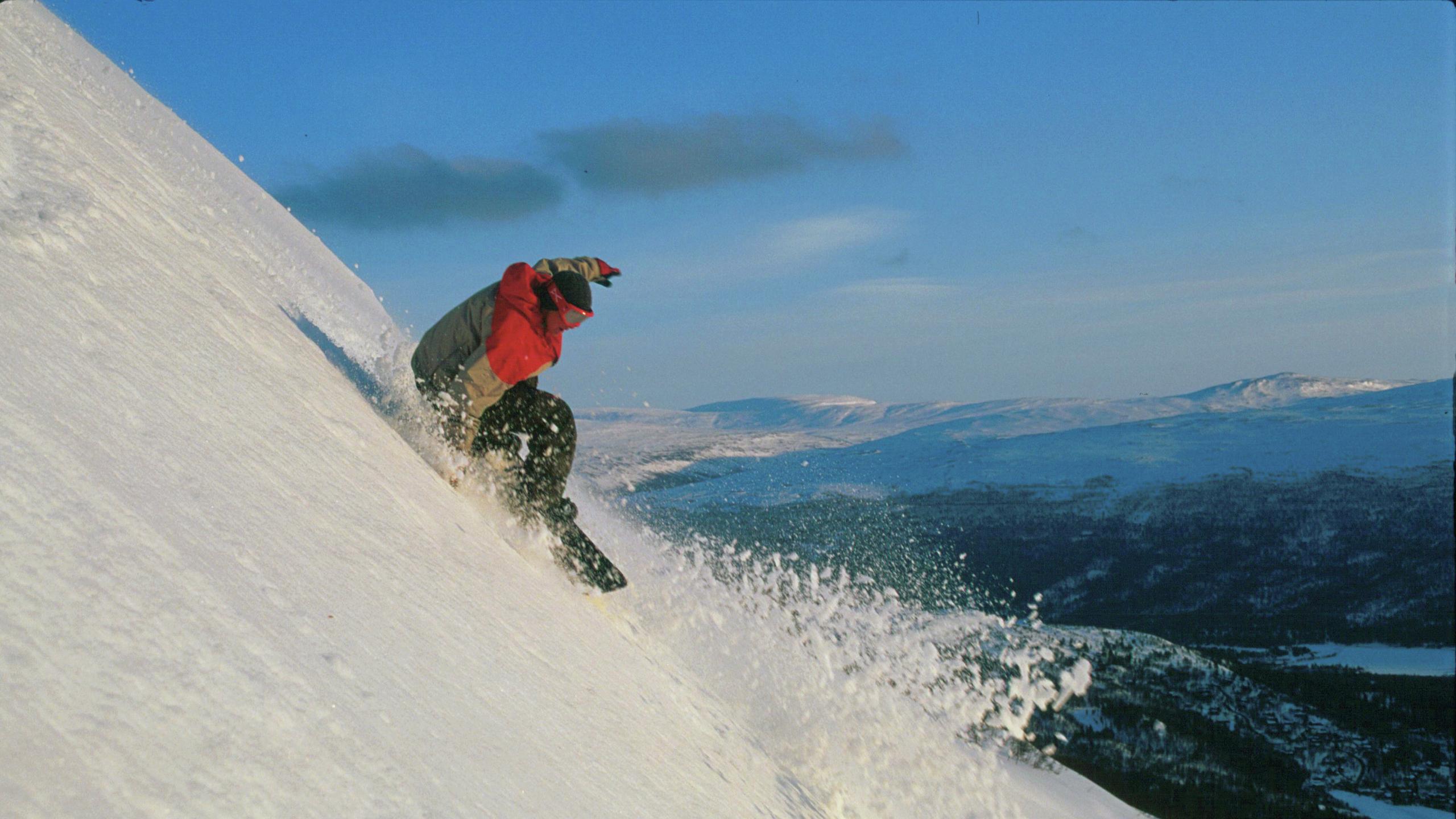 En mann kjører snowboard på Bjorli