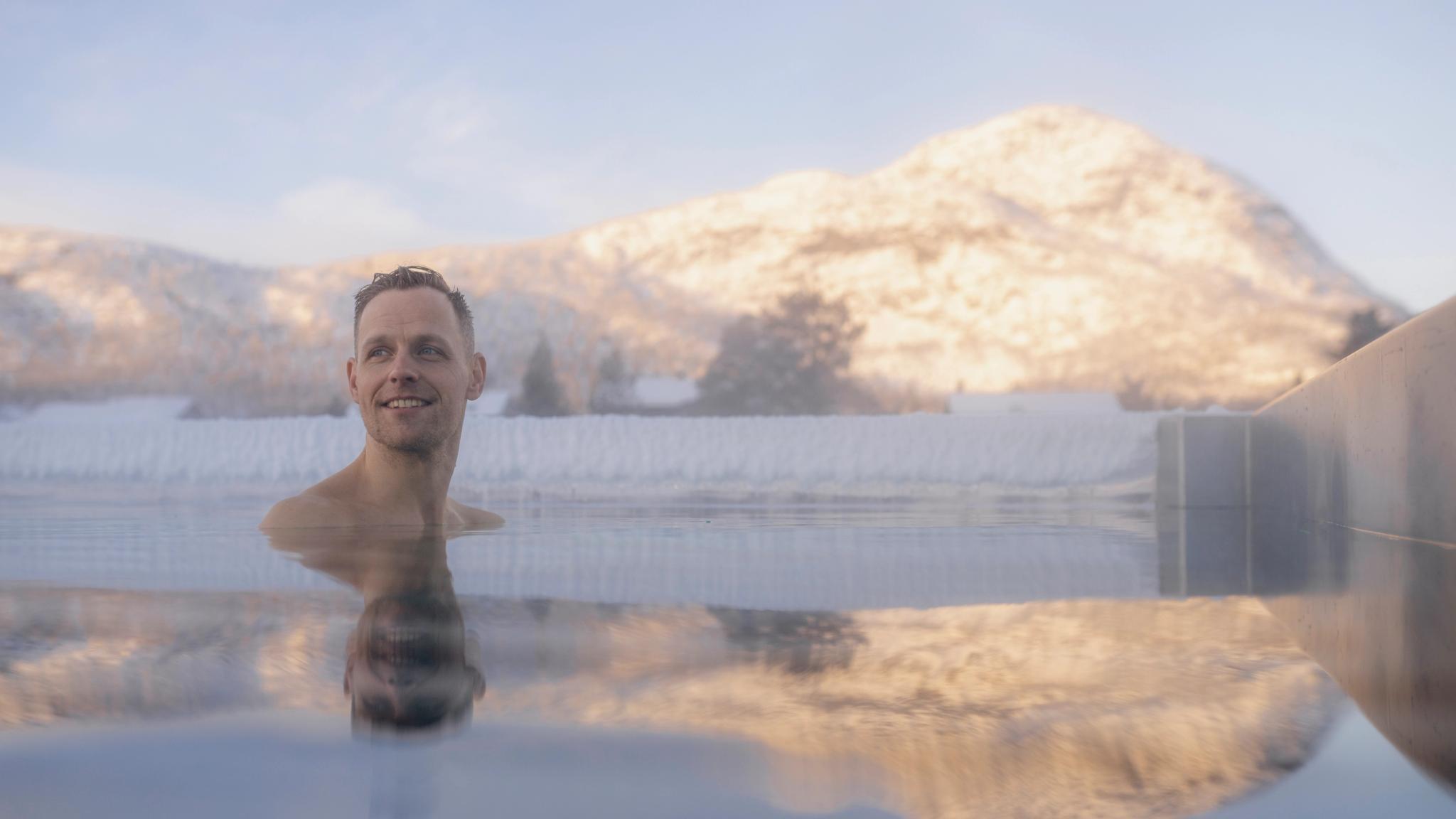 A person swimming in the outside pool during winter at Hovden fjellbad spa in Hovden