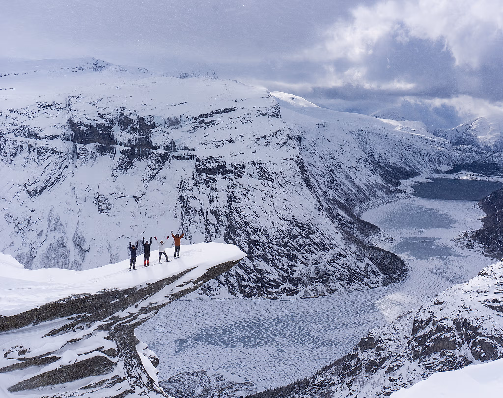 Four people with snowshoes at Trolltunga in Fjord Norway