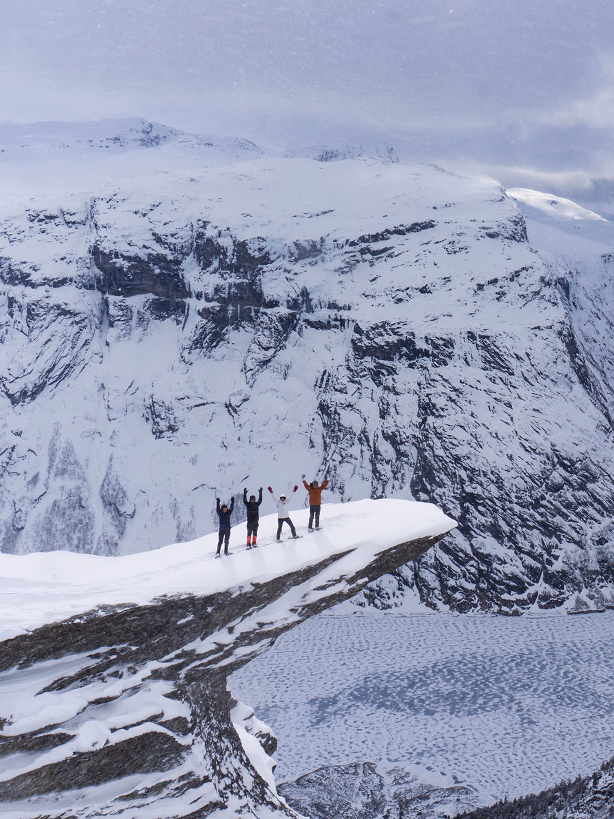 Fire personer med truger på Trolltunga på Vestlandet