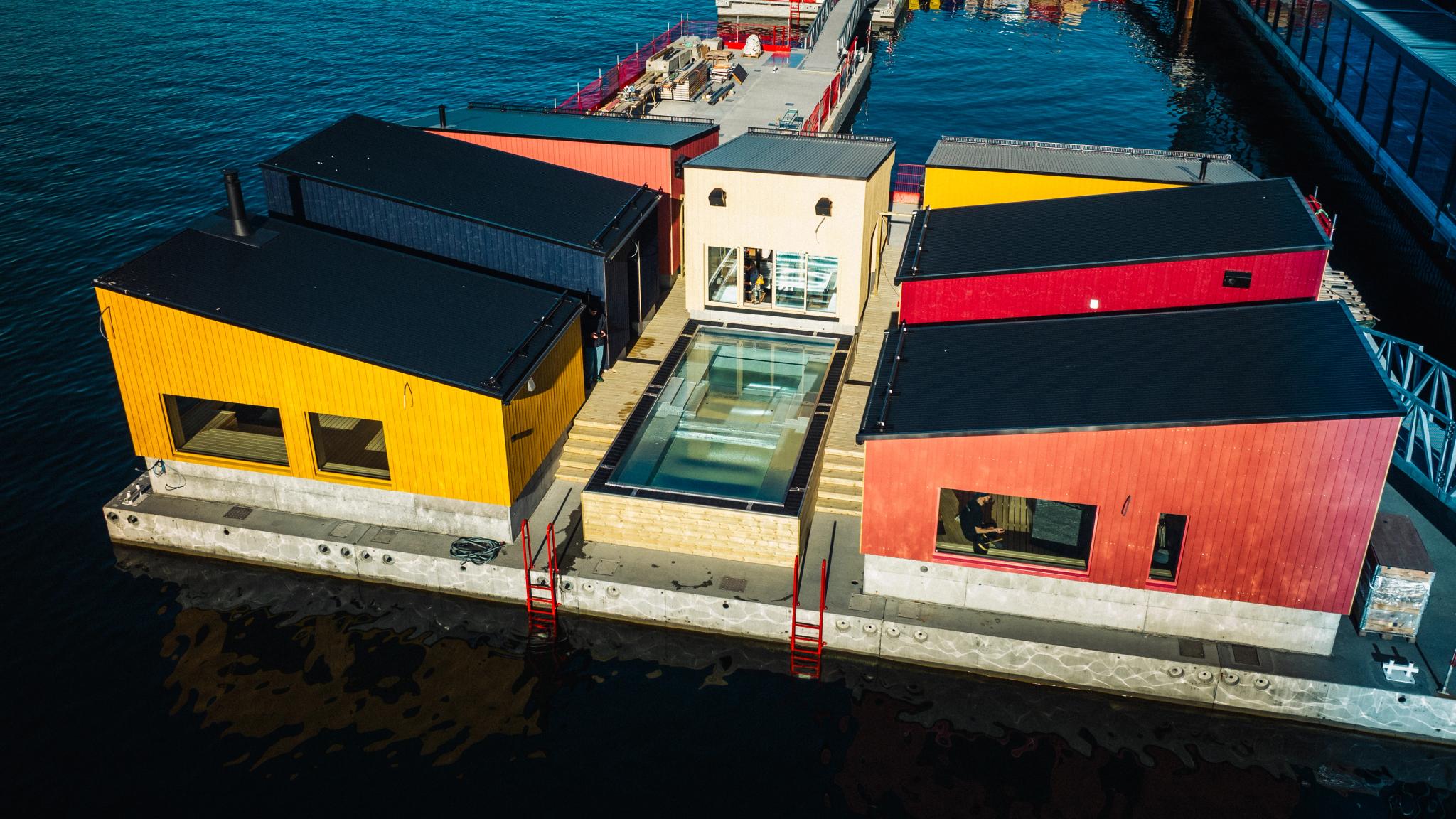 Several floating saunas connected on a dock.