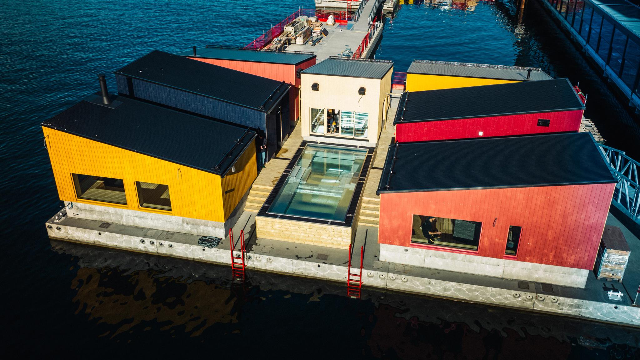 Several floating saunas connected on a dock.