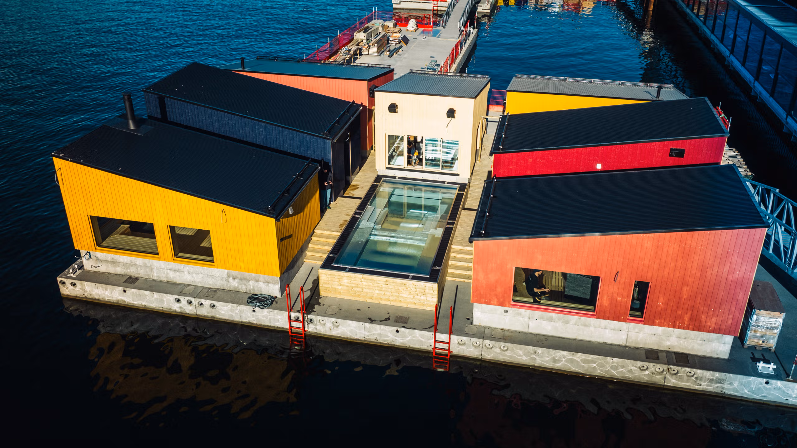 Several floating saunas connected on a dock.