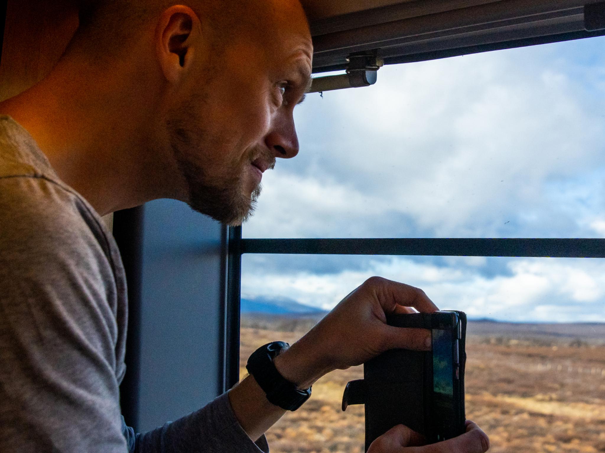 A man taking a picture at the Dovrefjell mountain on the Dovre Railway