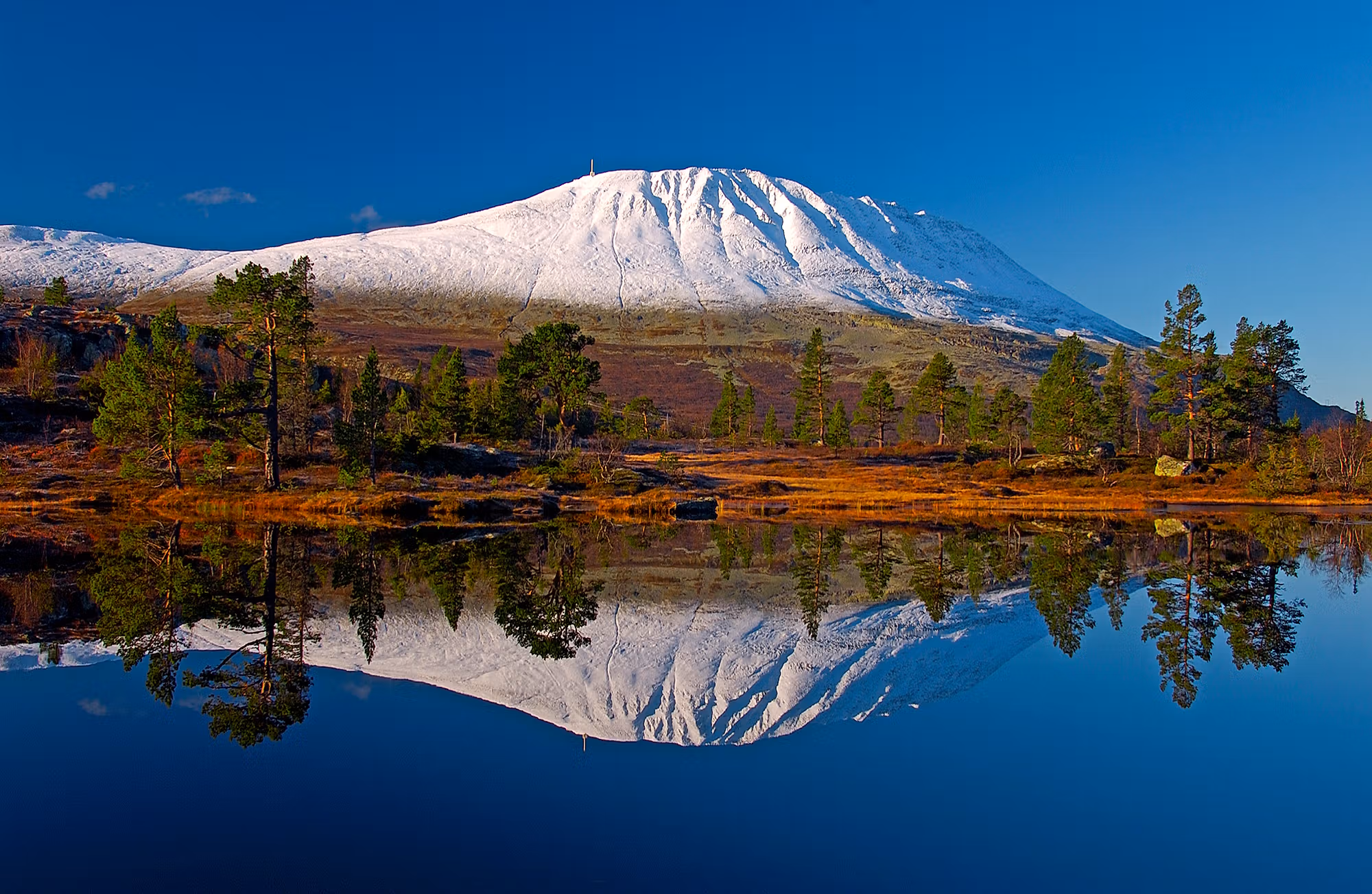 A snow-covered Gaustatoppen reflecting in a lake, Telemark, Norway