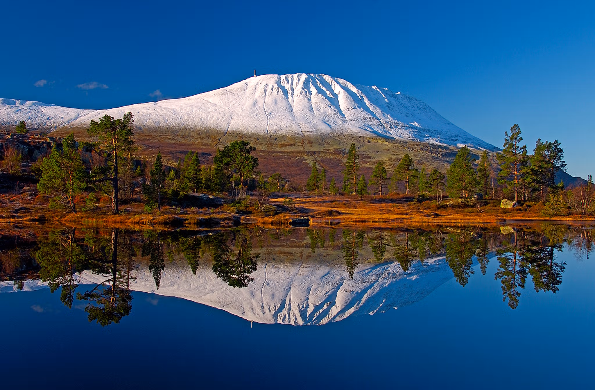 A snow-covered Gaustatoppen reflecting in a lake, Telemark, Norway