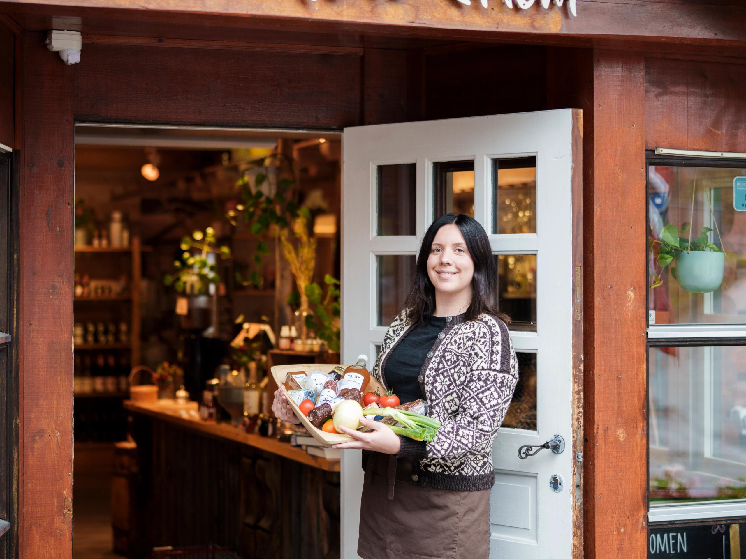 A woman holding a tray with local products.