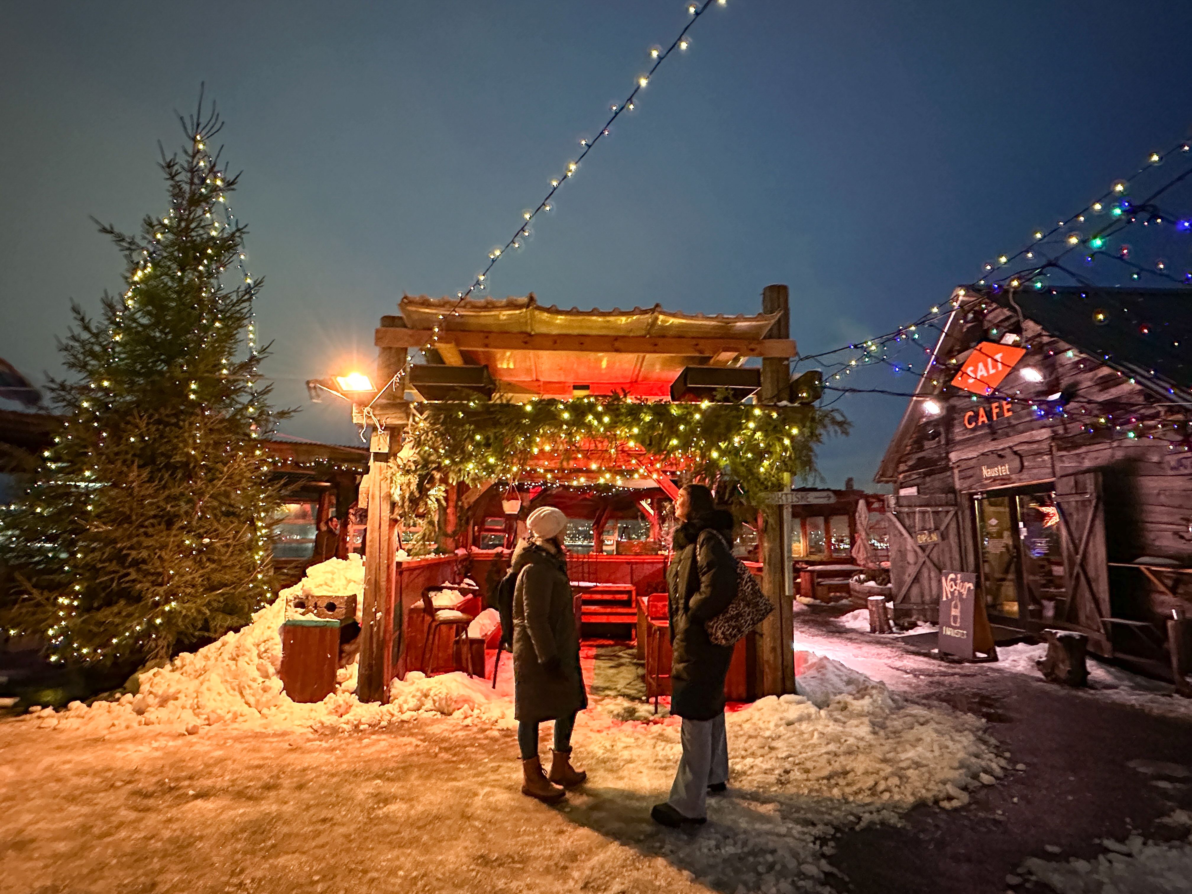 Two people in front of a Christmas stall at night at SALT in Oslo 