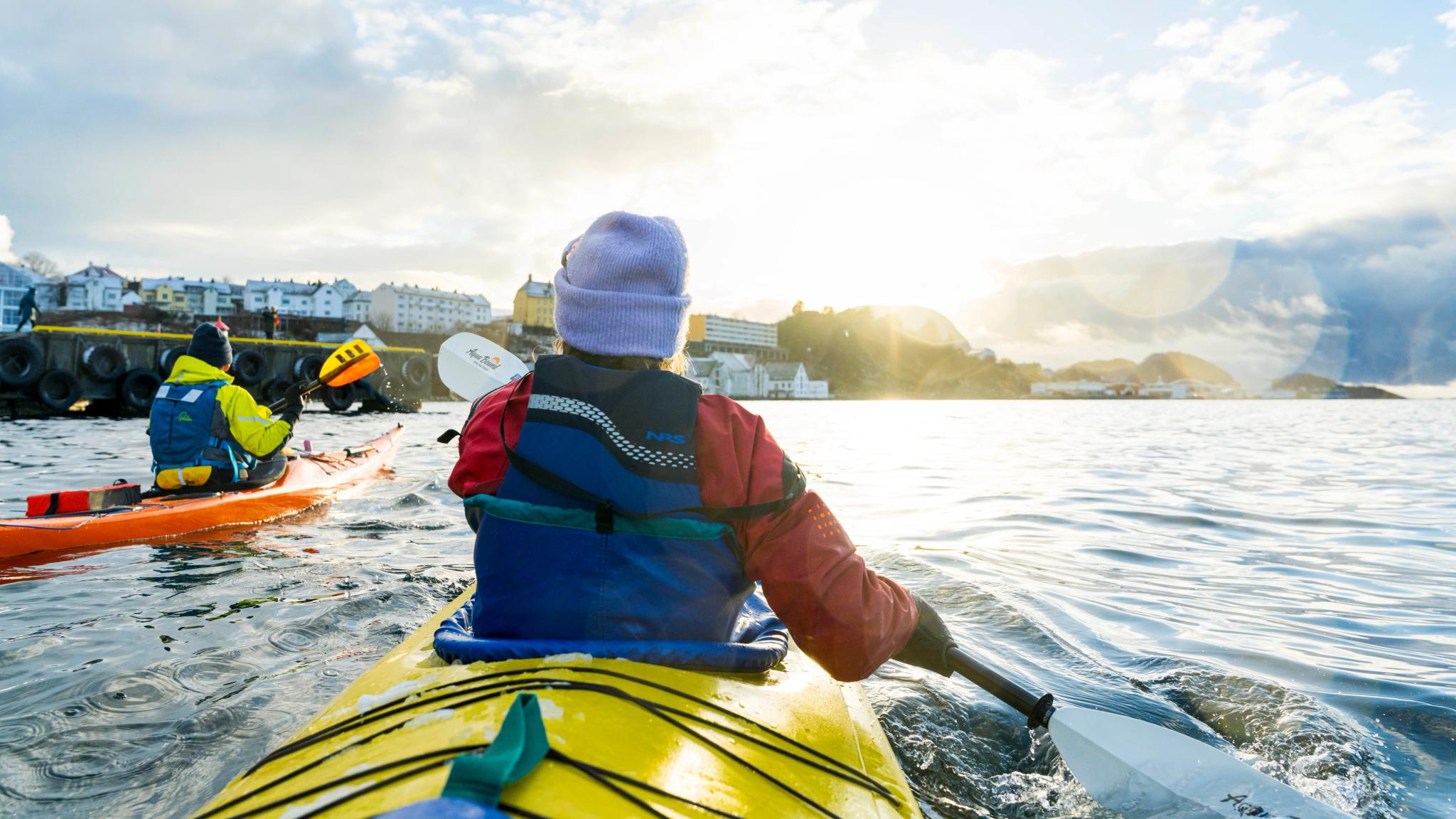 Two people kayaking outside the harbor in Ålesund, Fjord Norway