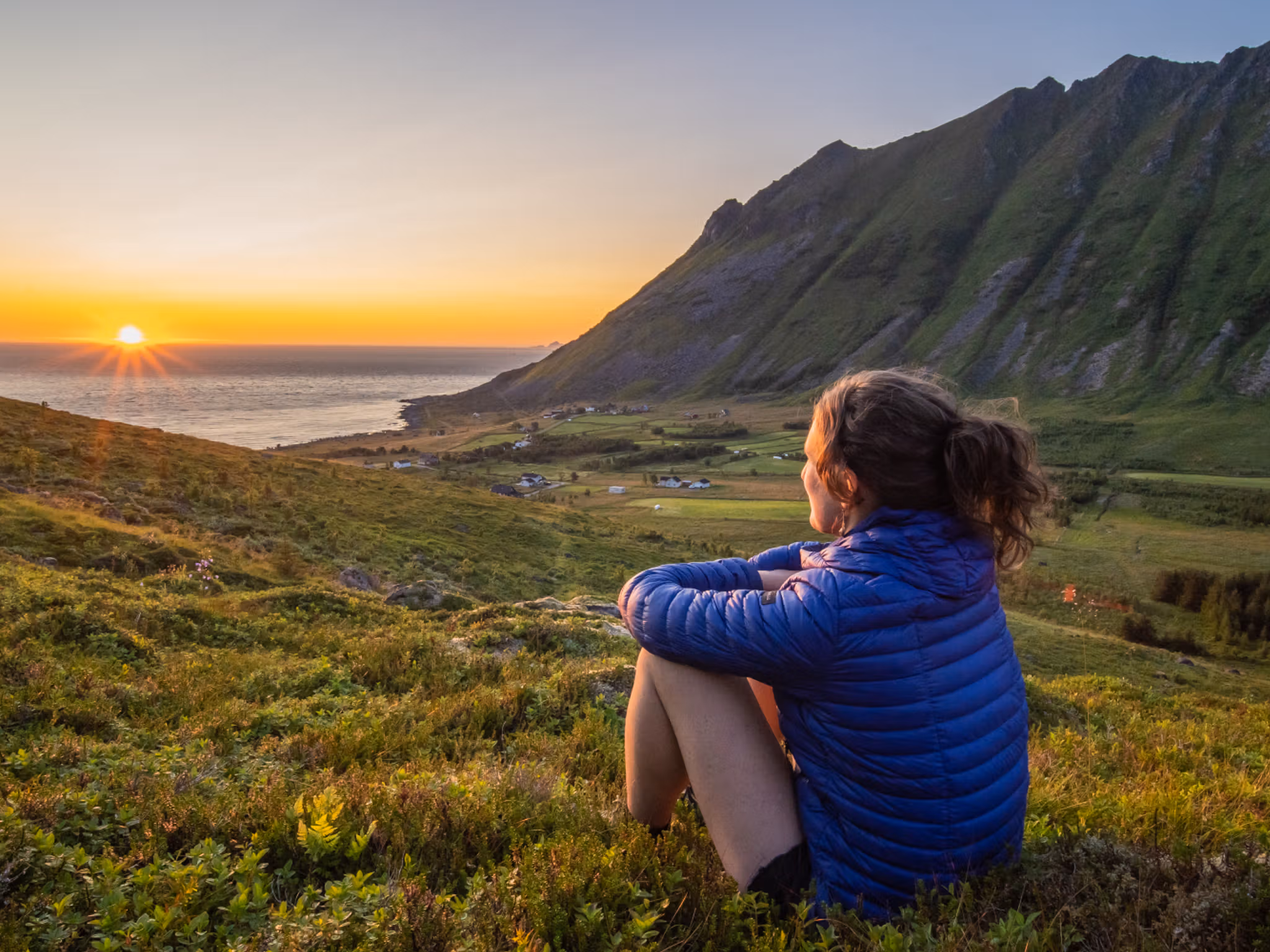 Woman looking at the midnightsun in Lofoten, Northern Norway