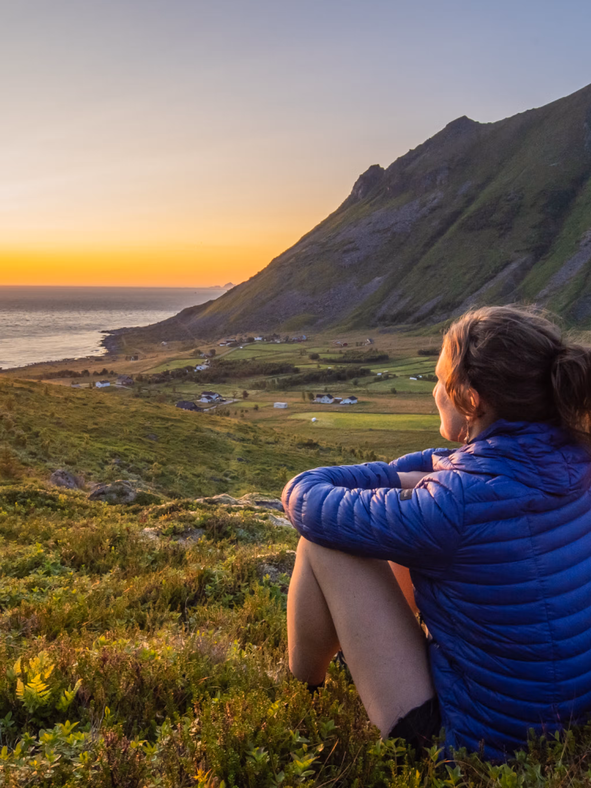 Woman looking at the midnightsun in Lofoten, Northern Norway