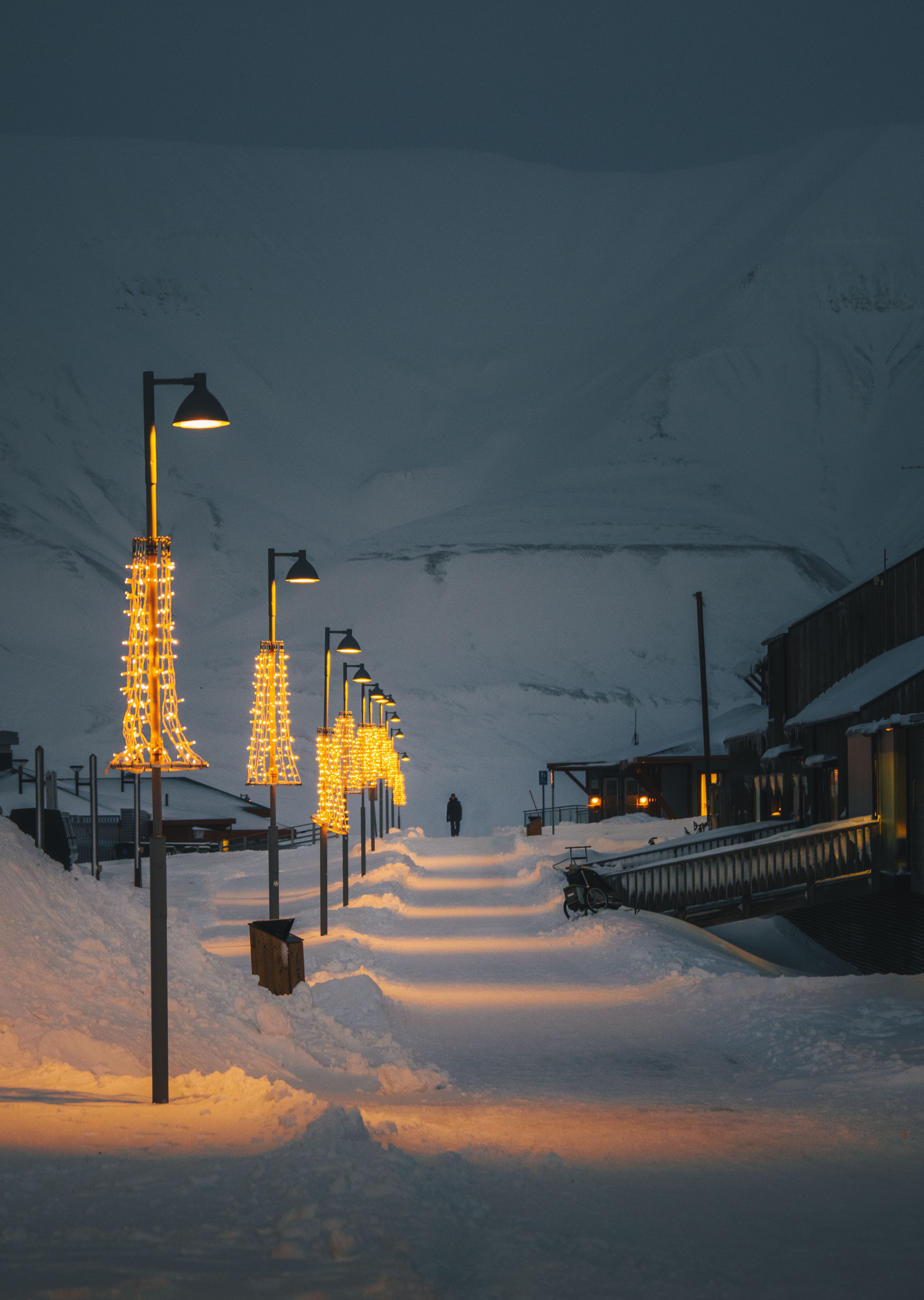 A person walking along Longyearbyen walkway during polar night