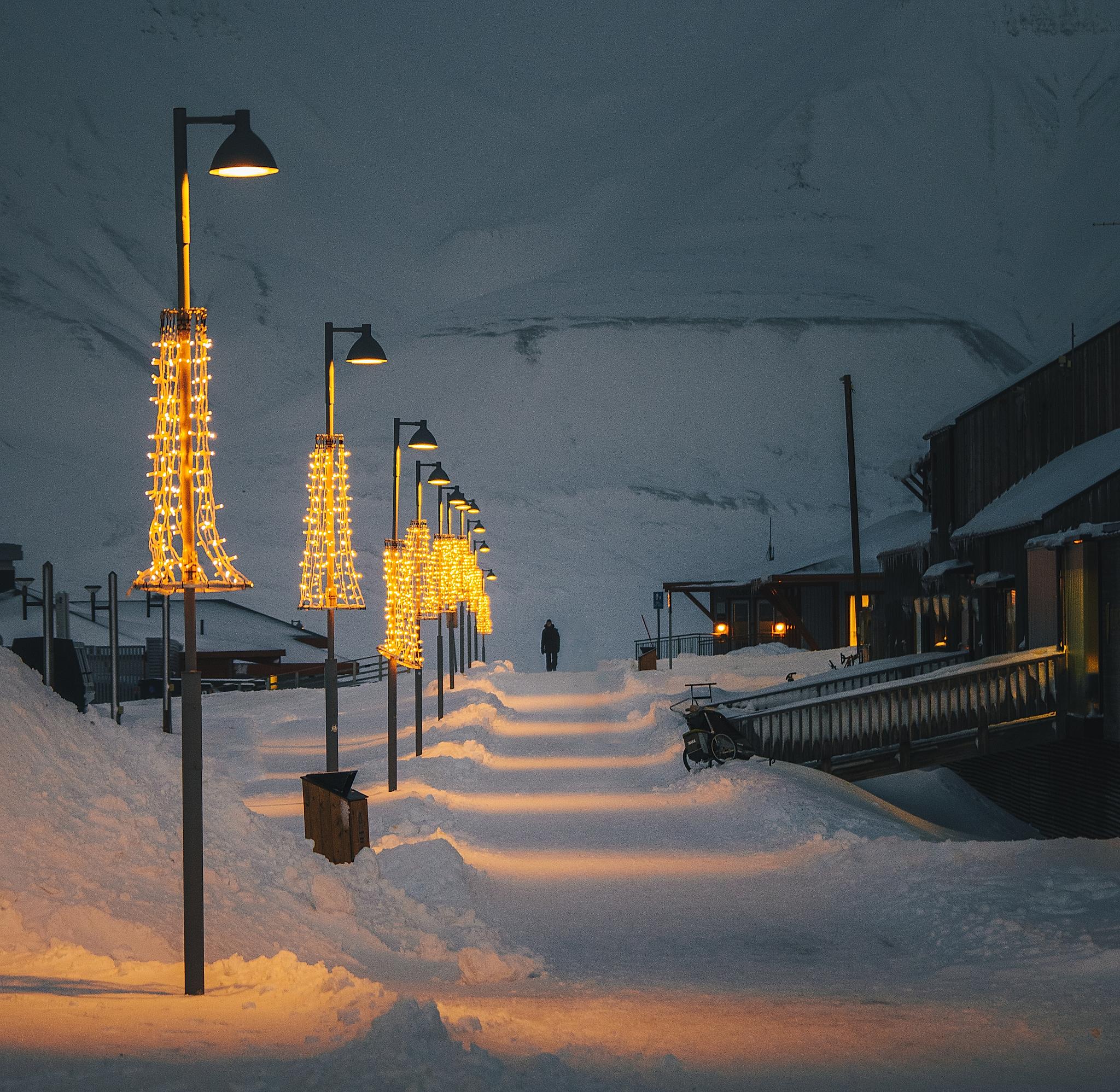A person walking along Longyearbyen walkway during polar night