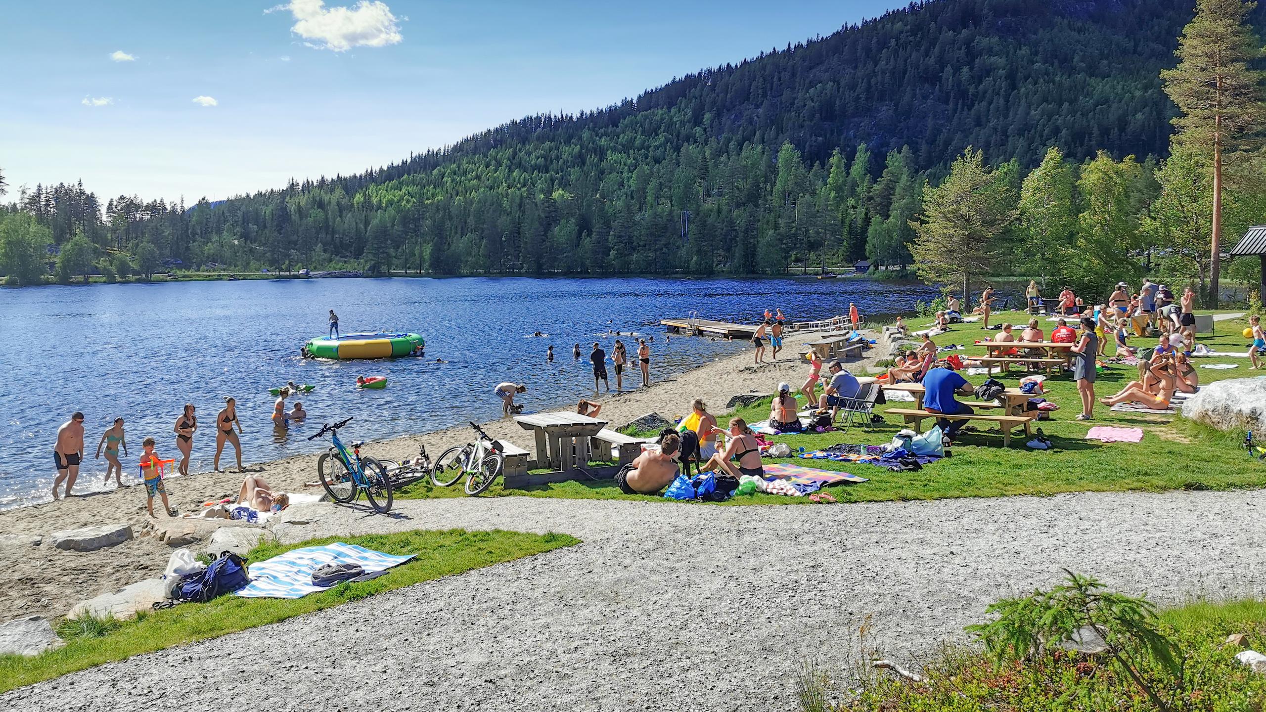 People swimming and sunbathing at Trytjern, Eastern Norway.