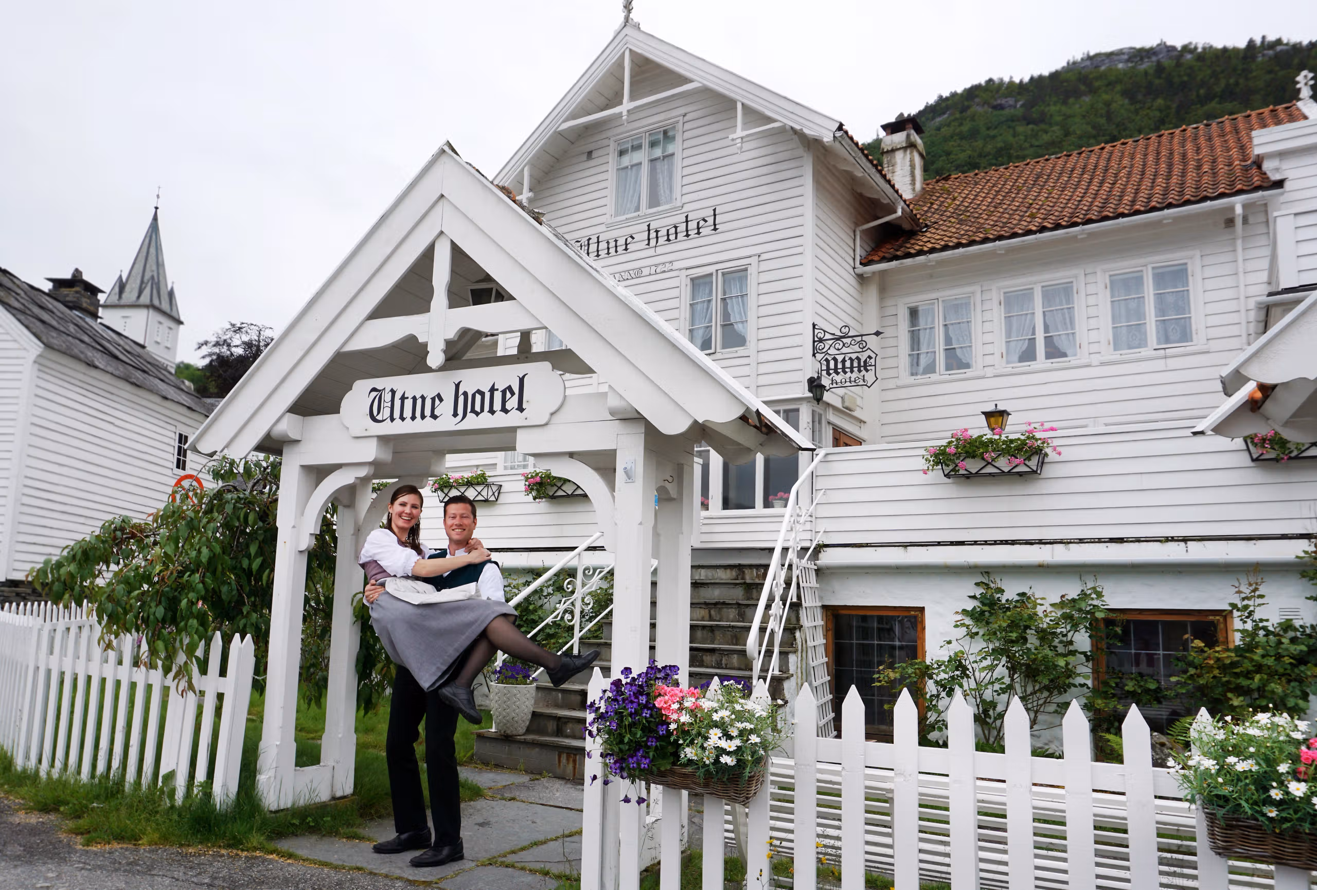 Bente R. and Kjetil Widding, eigenaars van het Utne Hotel, staan net buiten het hotel in de regio Hardangerfjord in Fjord-Noorwegen
