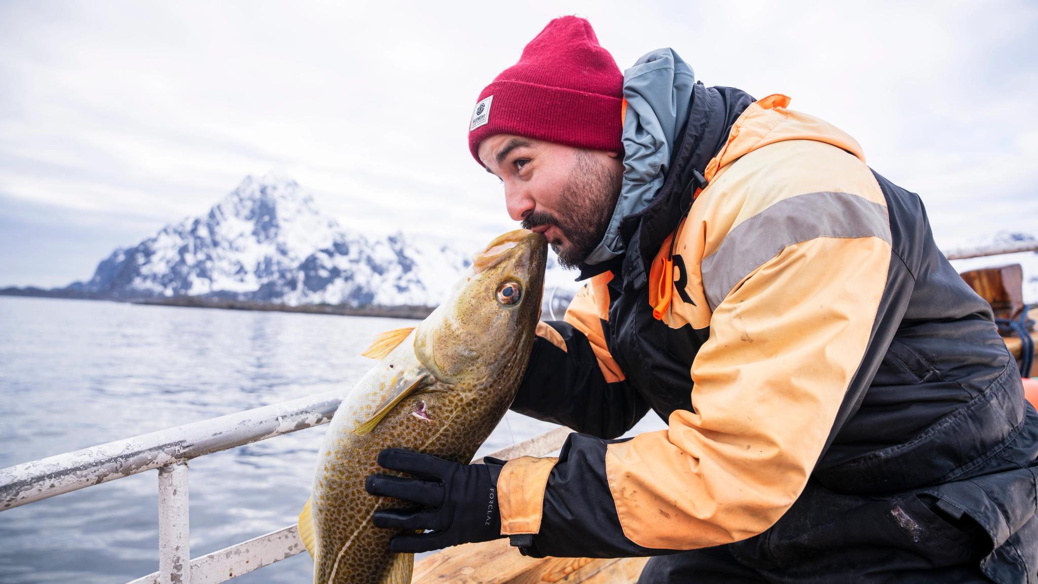 Man som kysser en Skrei på fisketur
