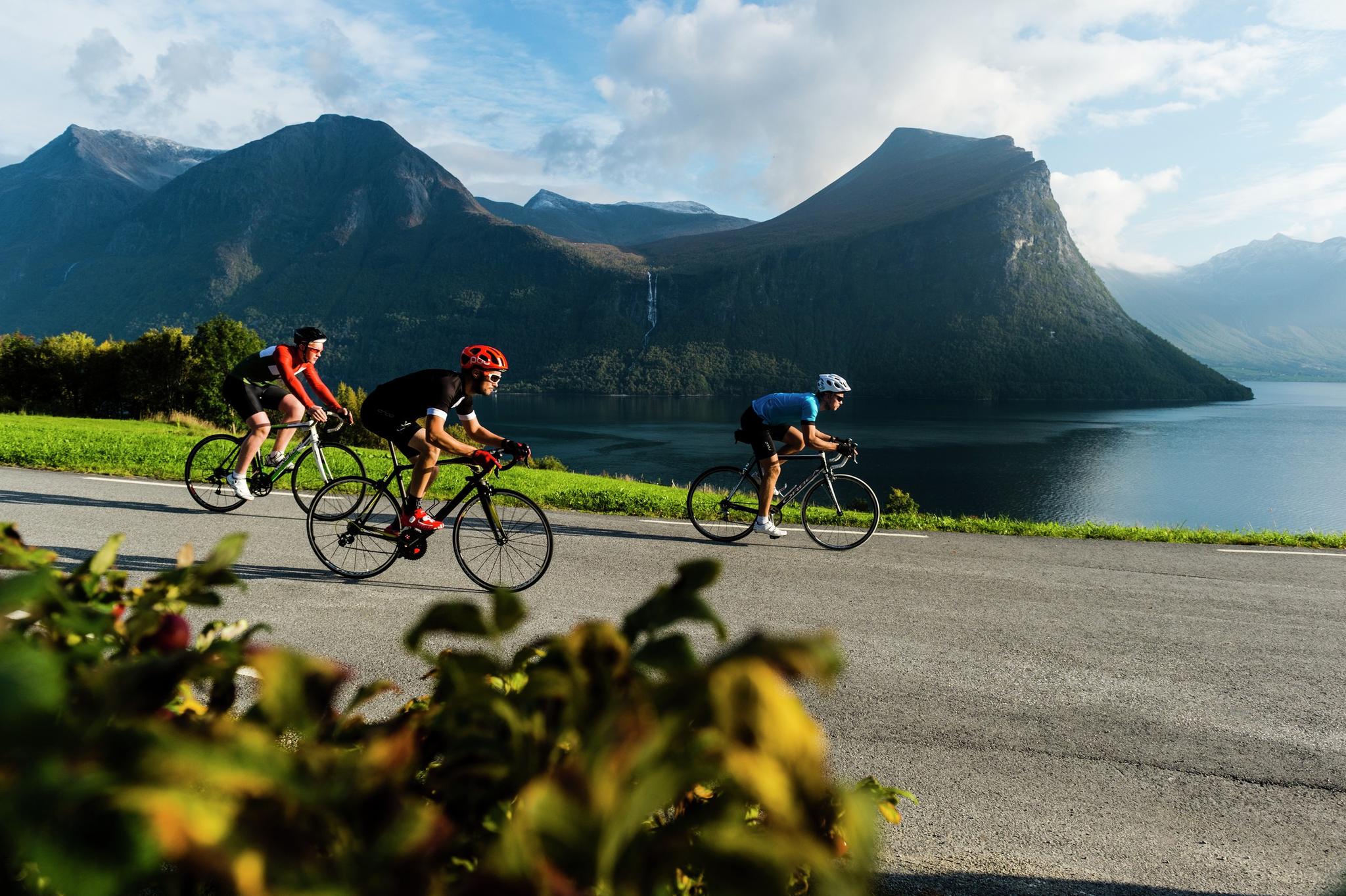 Varias personas practican ciclismo en carretera en Isfjorden, Noruega.