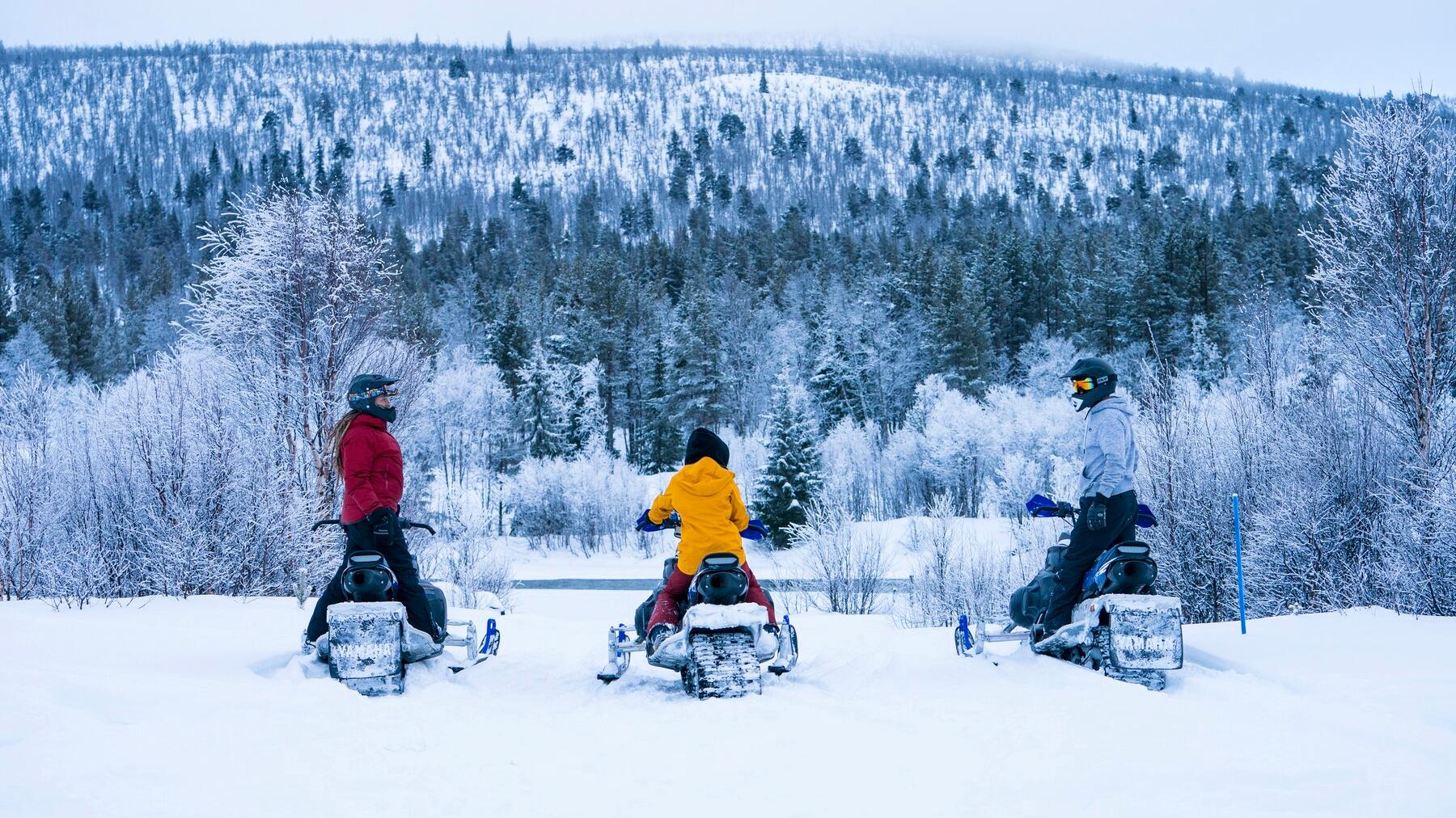 Tre personer sitter på snøskuter i Dagali, Geilo, Østlandet, Norge.