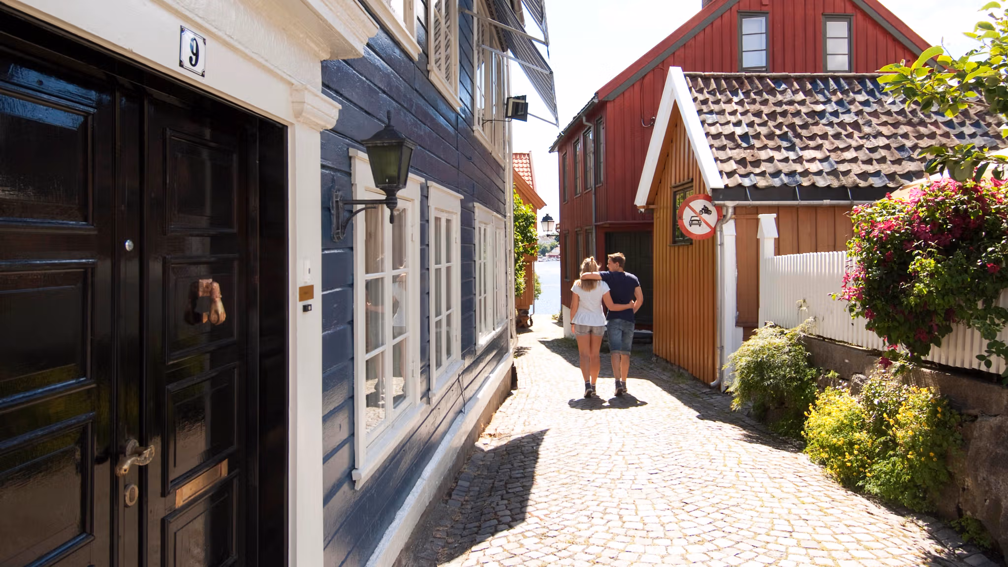 A couple wandering down a cobblestone street in Arendal, Southern Norway.