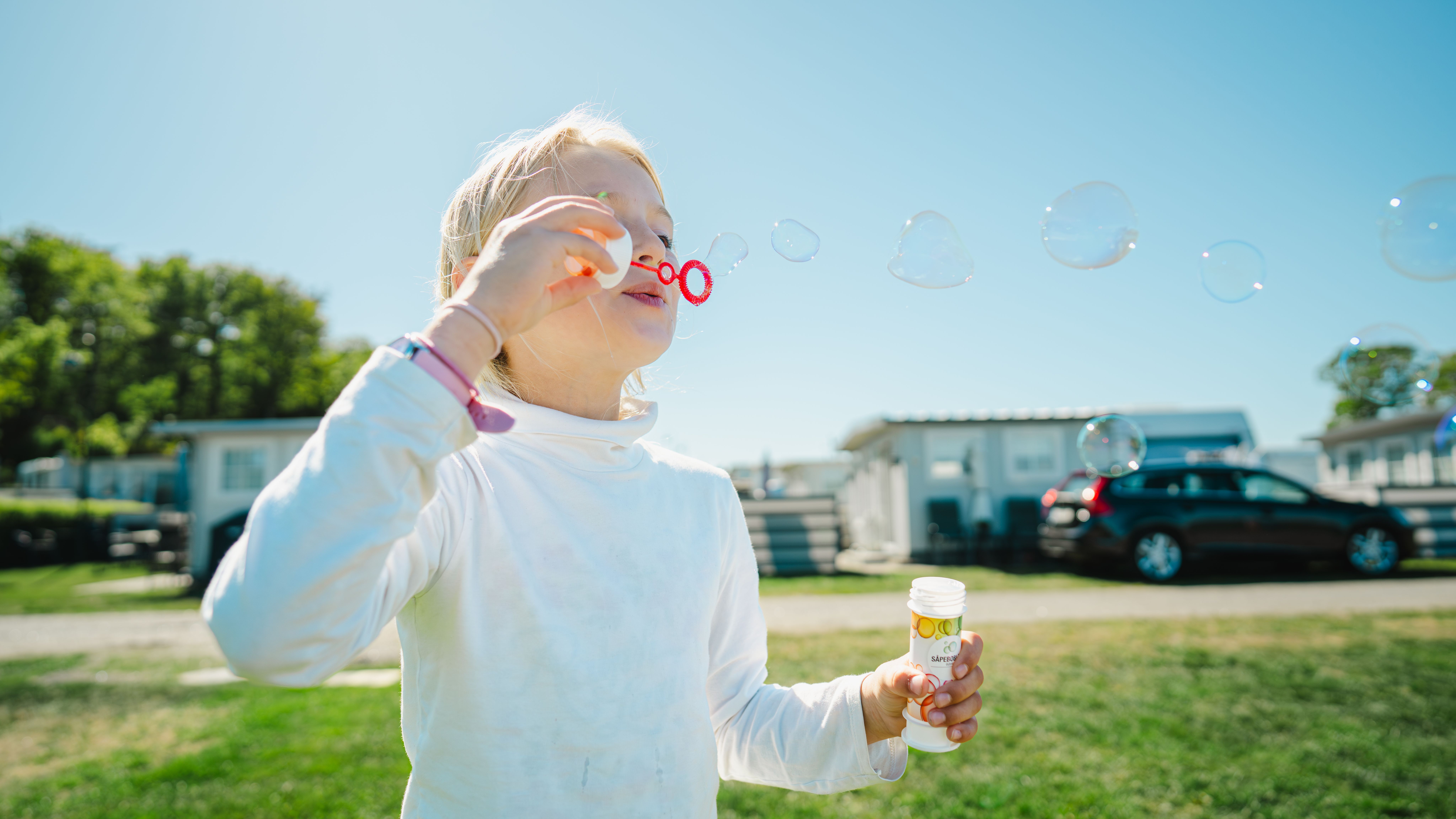 A girl blowing bubbles on a camping holiday