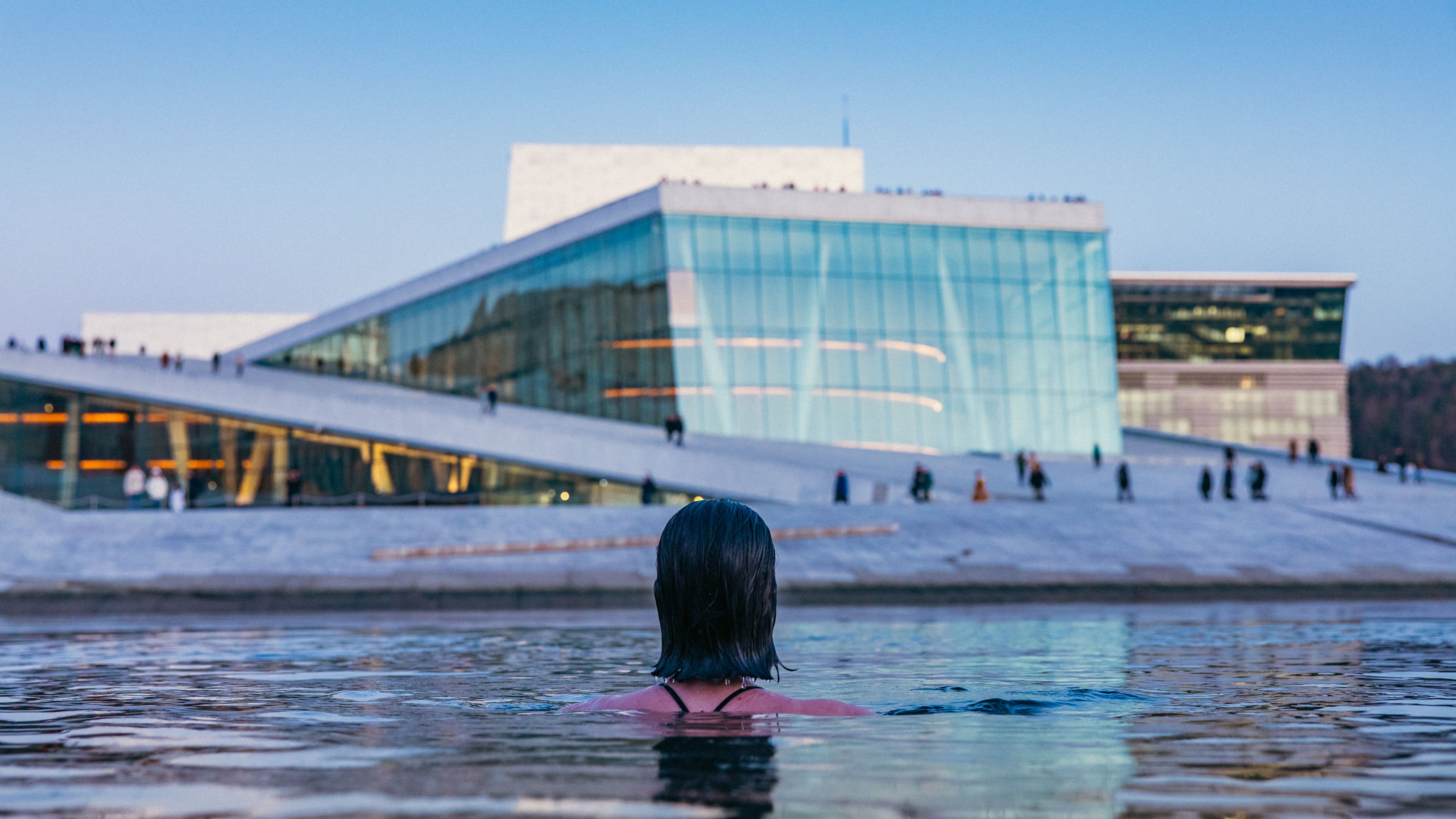 A woman ice bathing in front of the Opera house in Oslo.