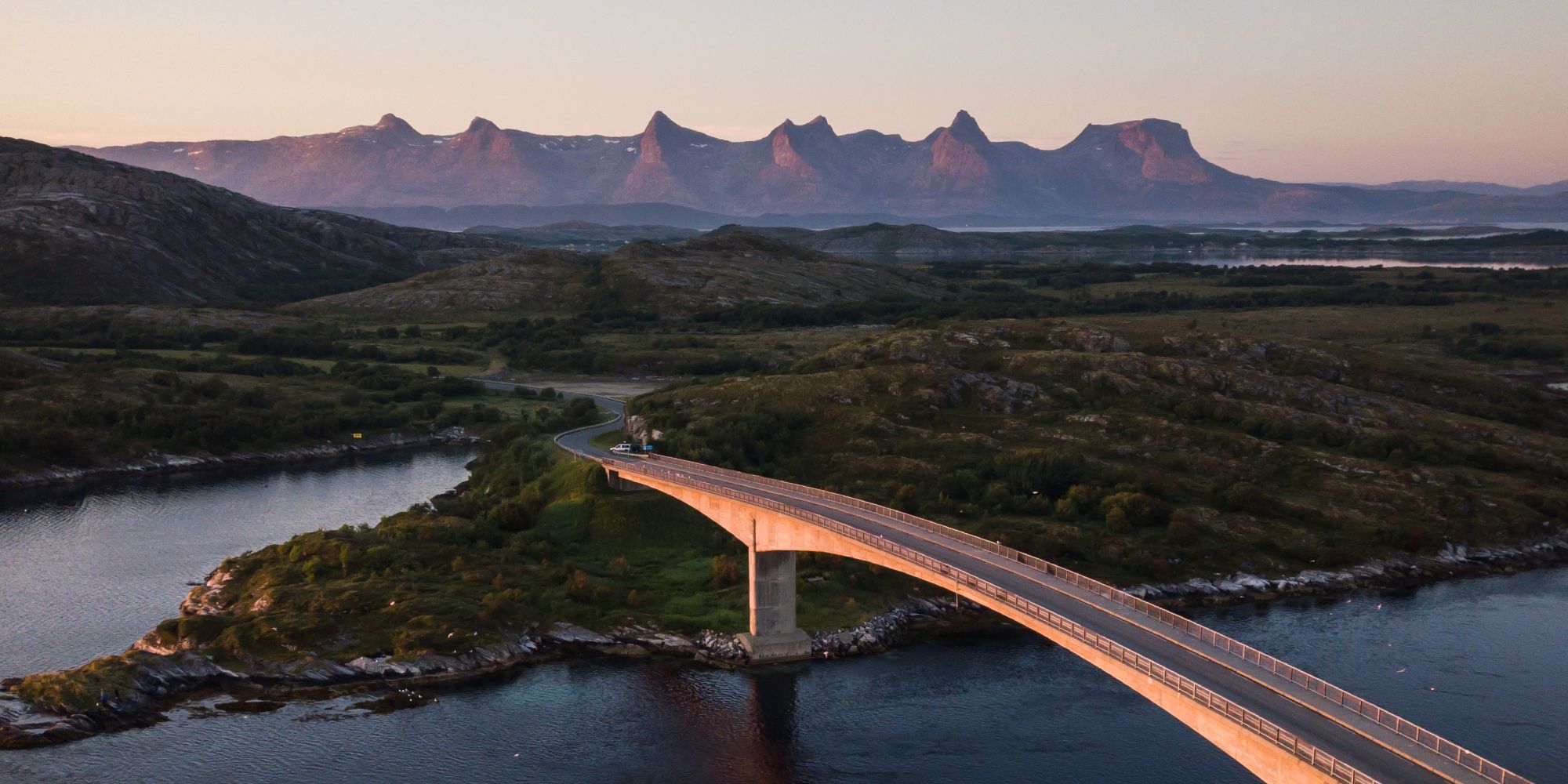 A bridge connecting Herøy to another island in Helegeland, Northern Norway. In the background, the mountain range The seven sisters.