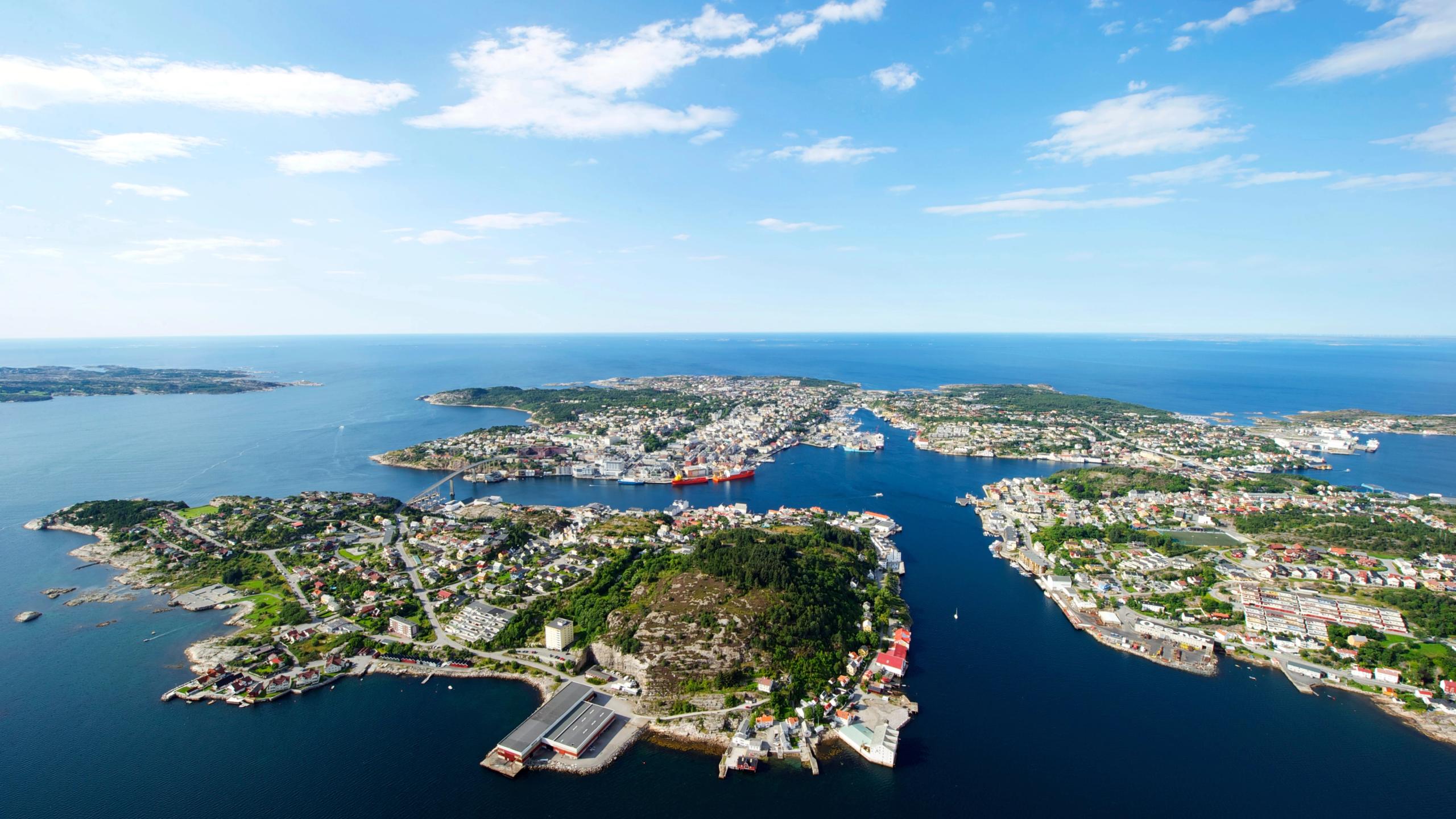 Kristiansund by og sjøen rundt i solskinn, sett ovenfra.