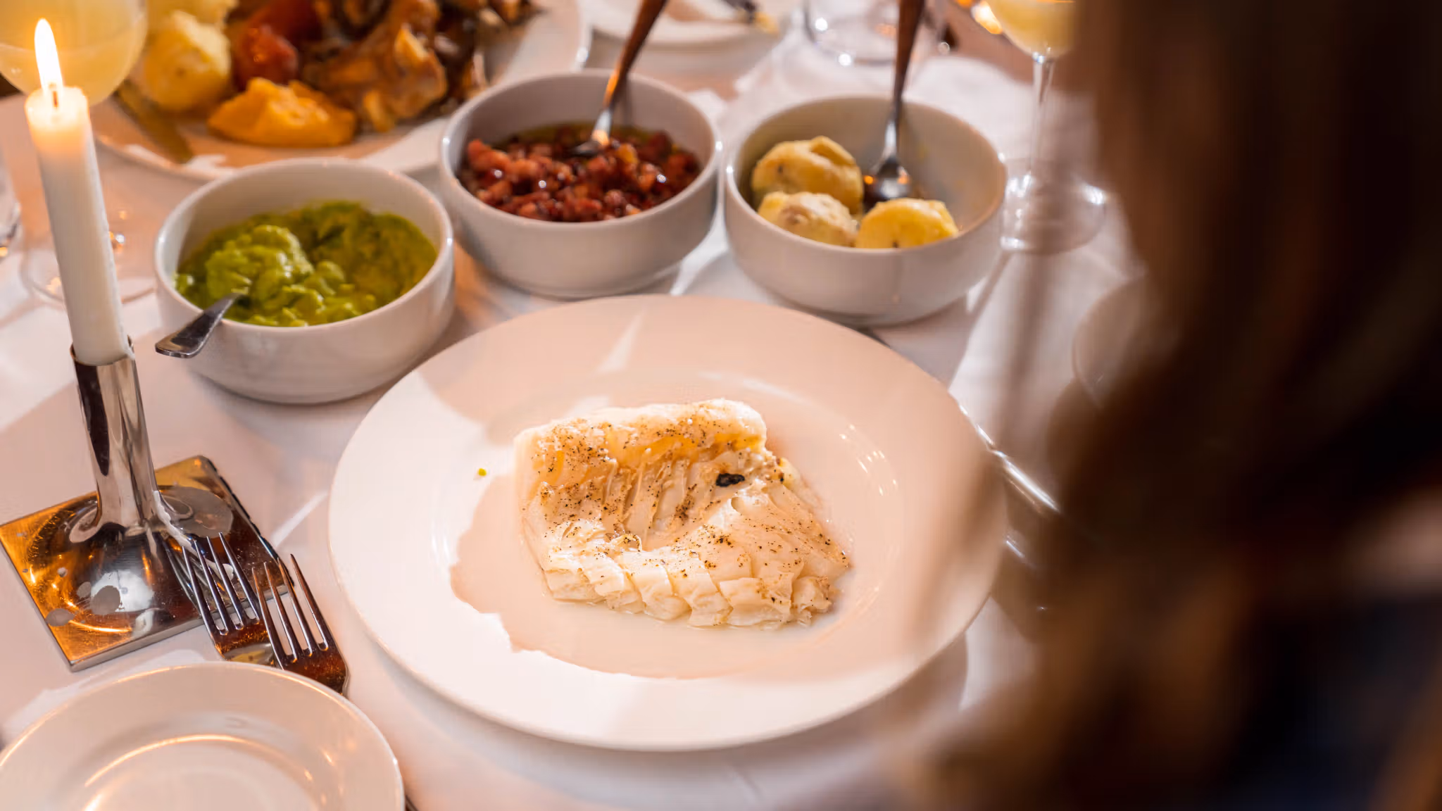 En tallerken med lutefisk og det mest vanlige tilbehøret, ertestuing, bacon og poteter