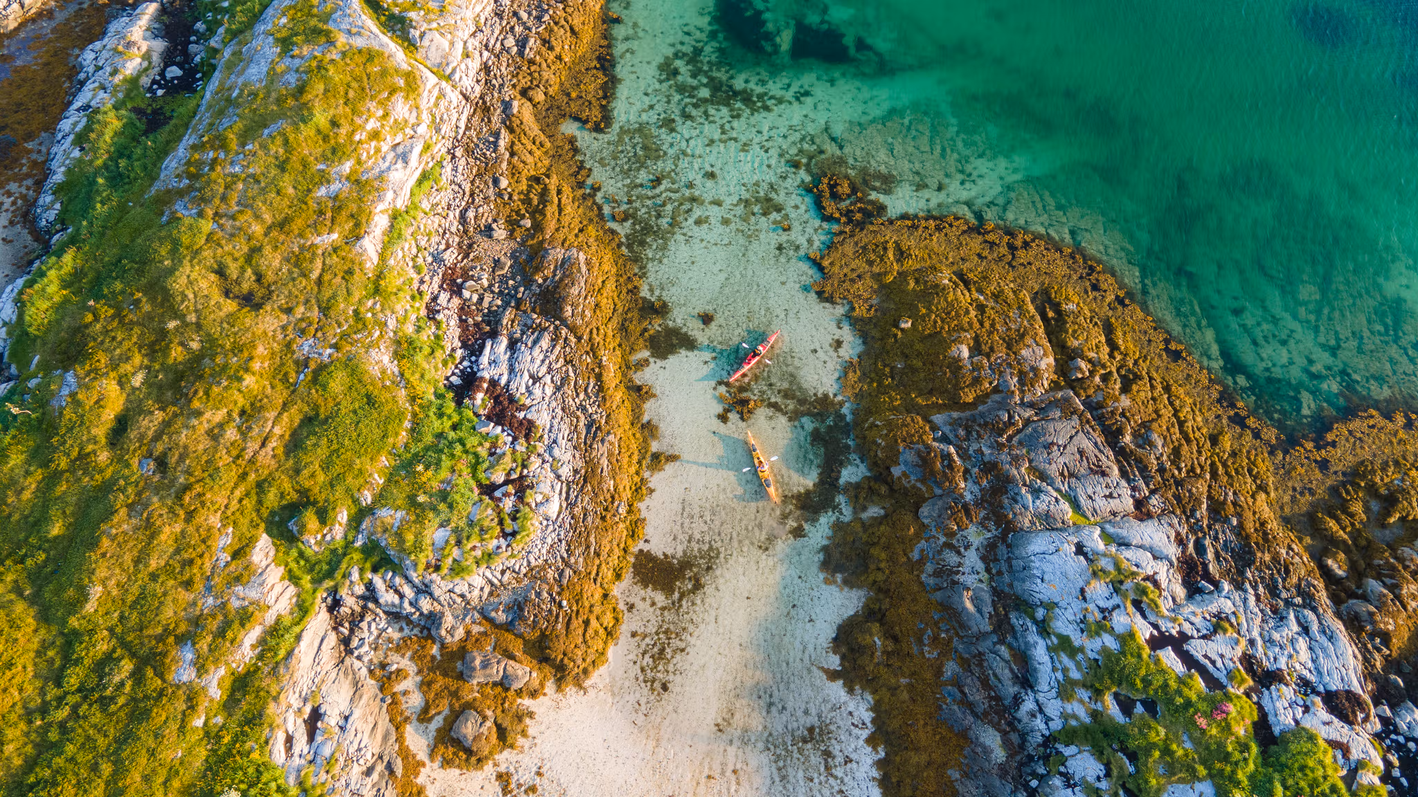 Two people kayaking in the evening sun in the archipelago in the Herøy Islands, Helgeland, Norway.