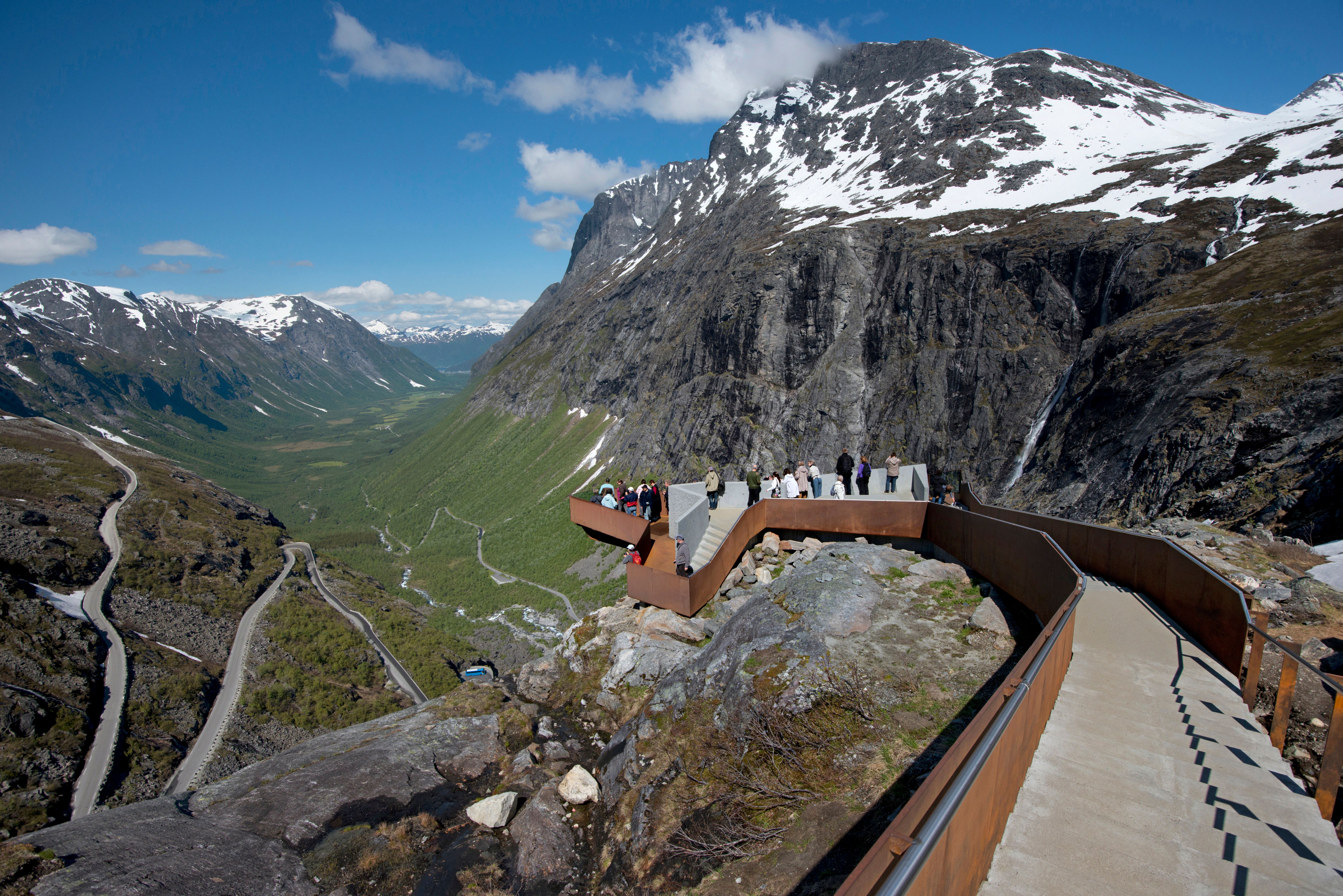 Folk beundrer utsikten over Nasjonal turistveg Trollstigen på Vestlandet fra et stilig utsiktspunkt