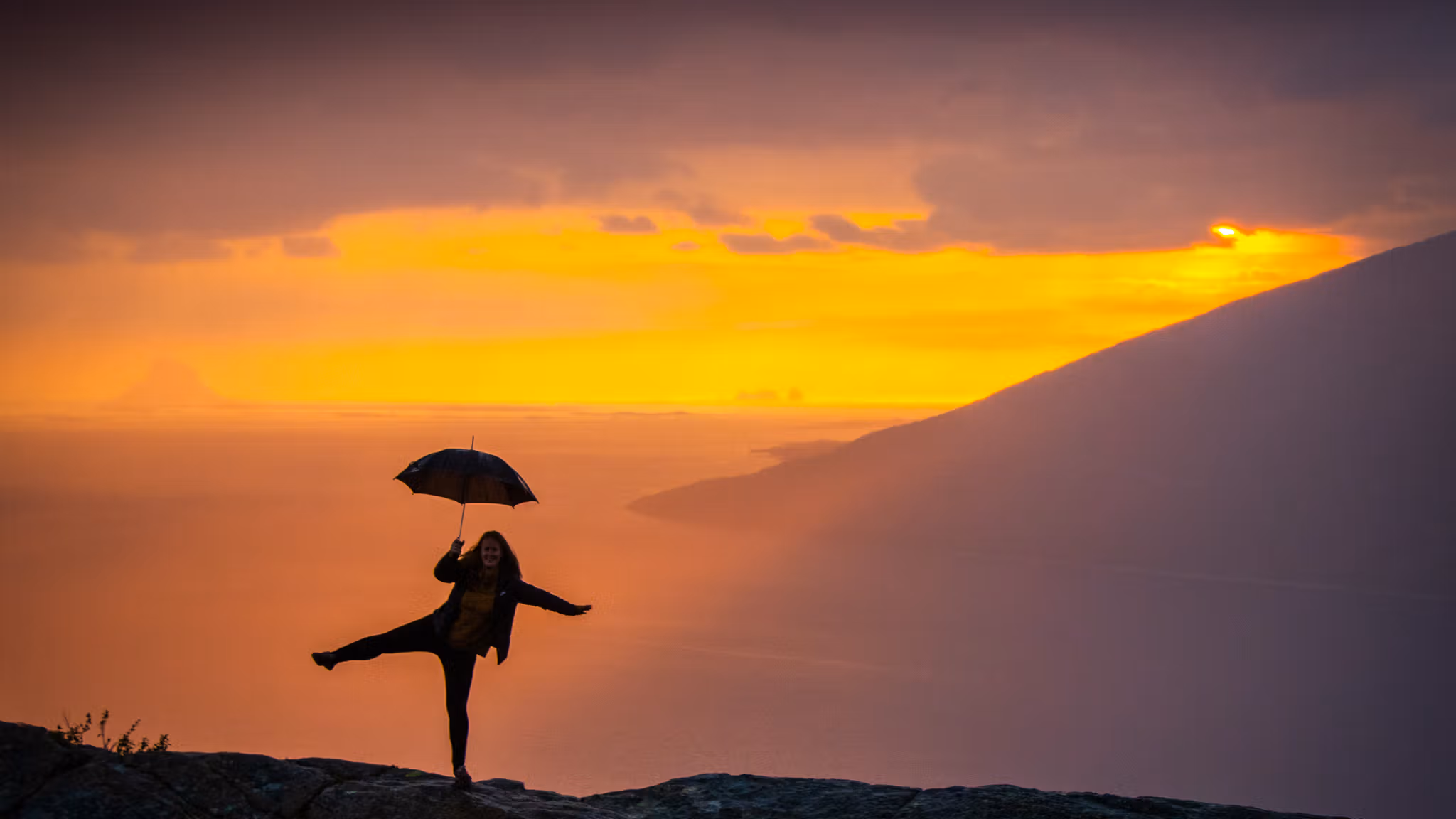 Girl holding an umbrella at the Sjonfjellet mountain in Northern Norway