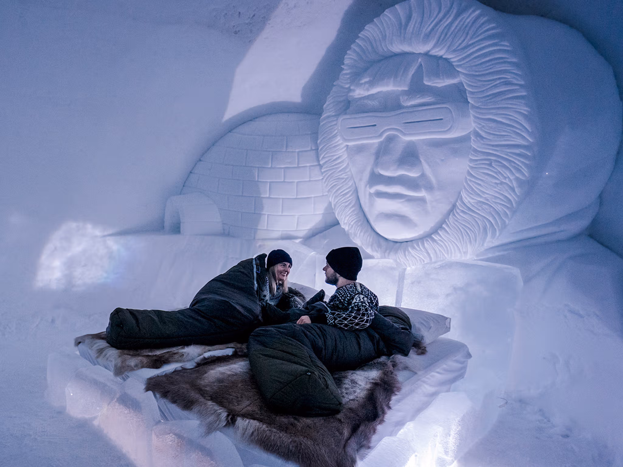 Två personer i ett sovrum gjort av is och snö på Tromsø Ice Domes i Nord-Norge