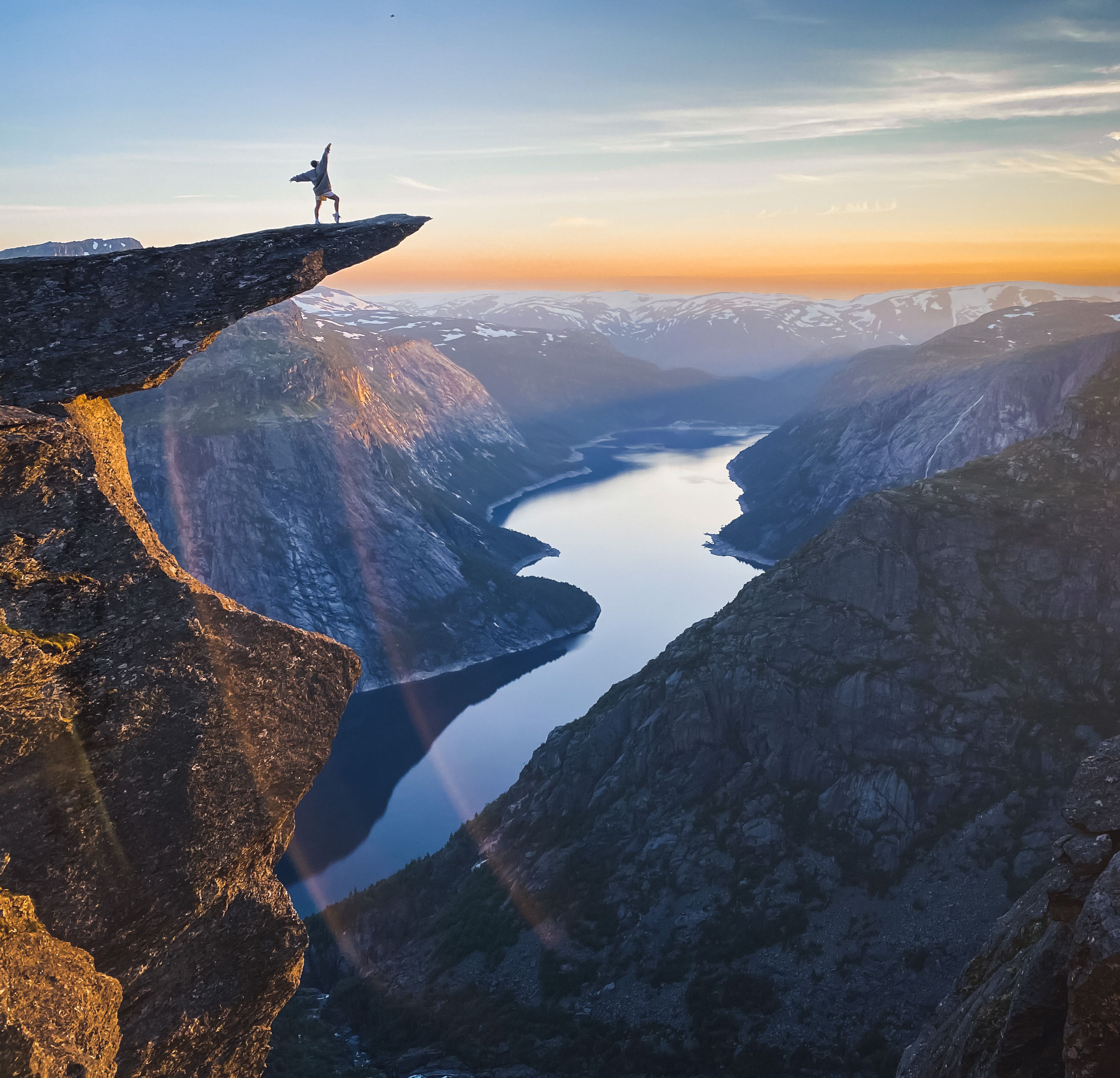 A person standing at Trolltunga overlooking Lake Ringedalsvatnet.