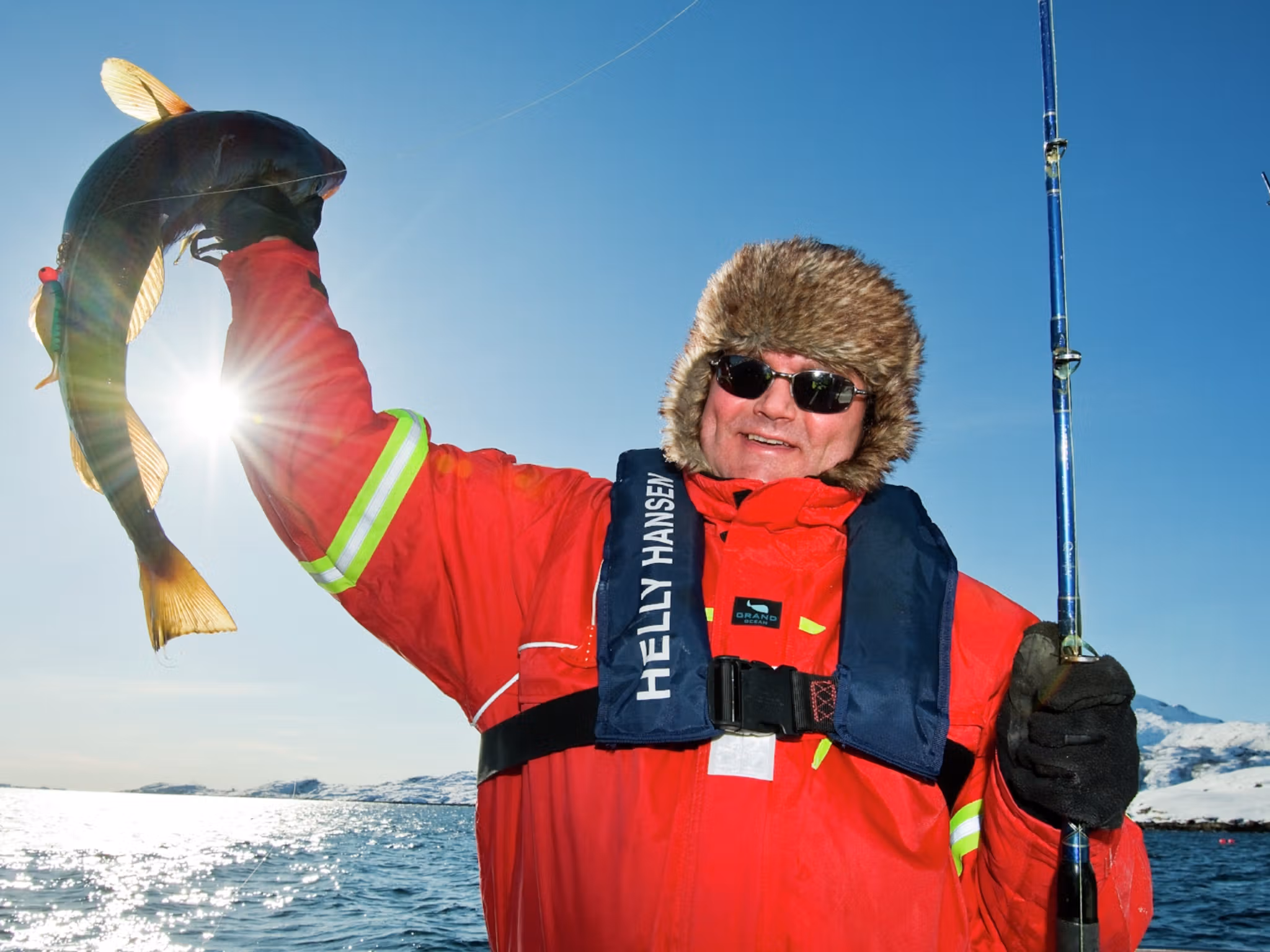 A man who has caught a fish in Austnesfjorden in Lofoten in Northern Norway