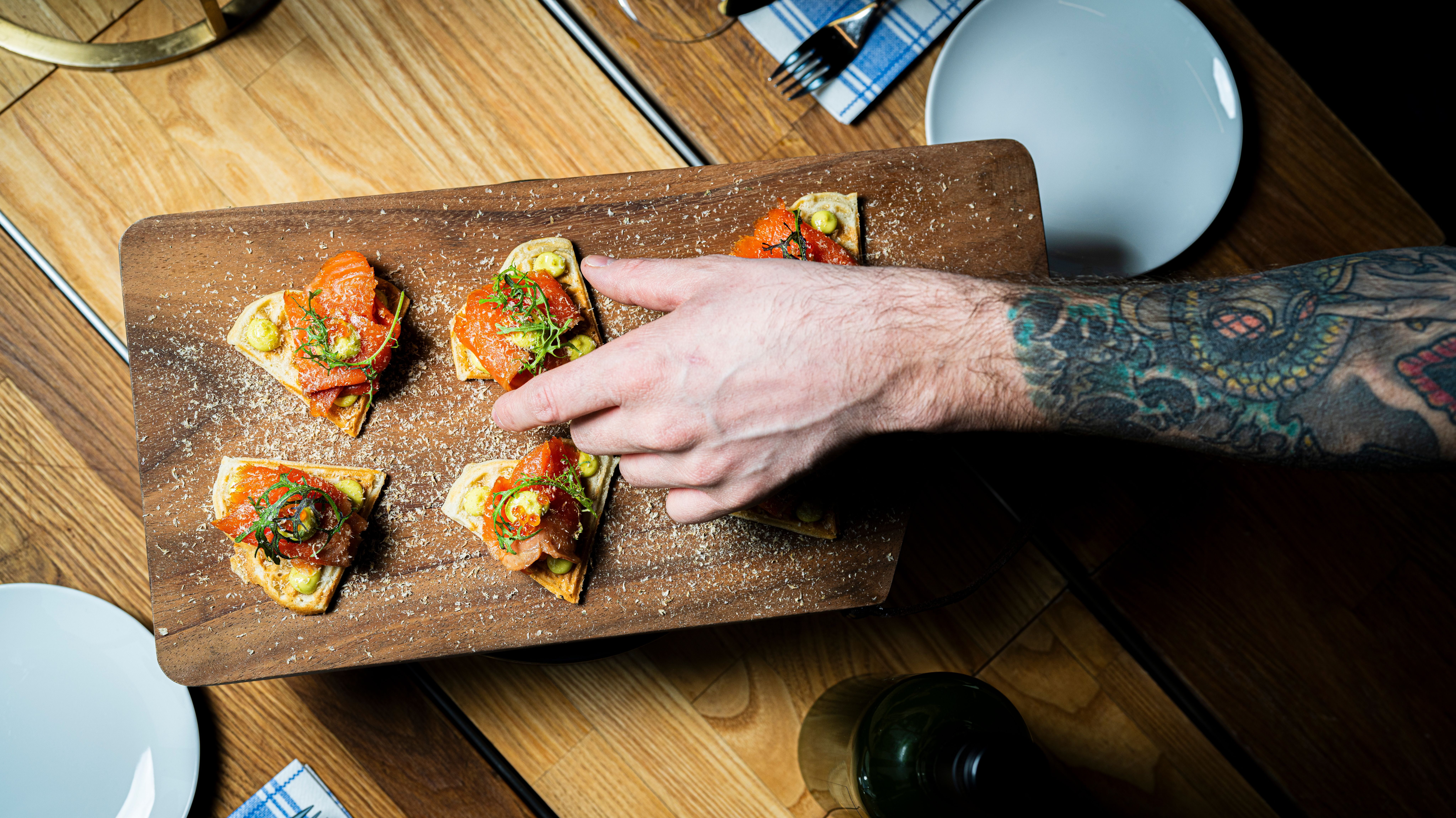 A hand grabbing a salmon snack.