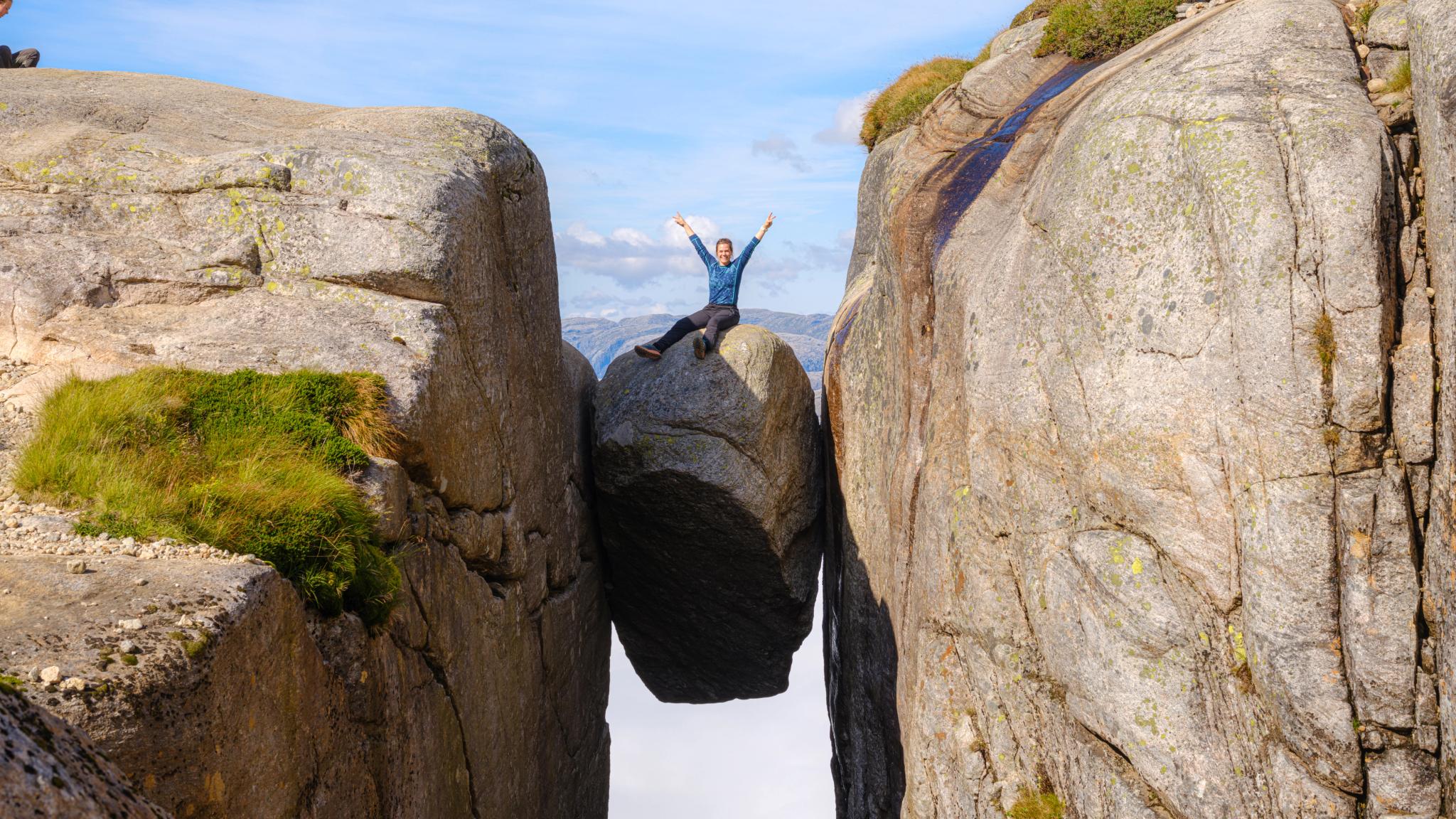 Woman sitting on Kjeragbolten in Lysefjord, Fjord Norway