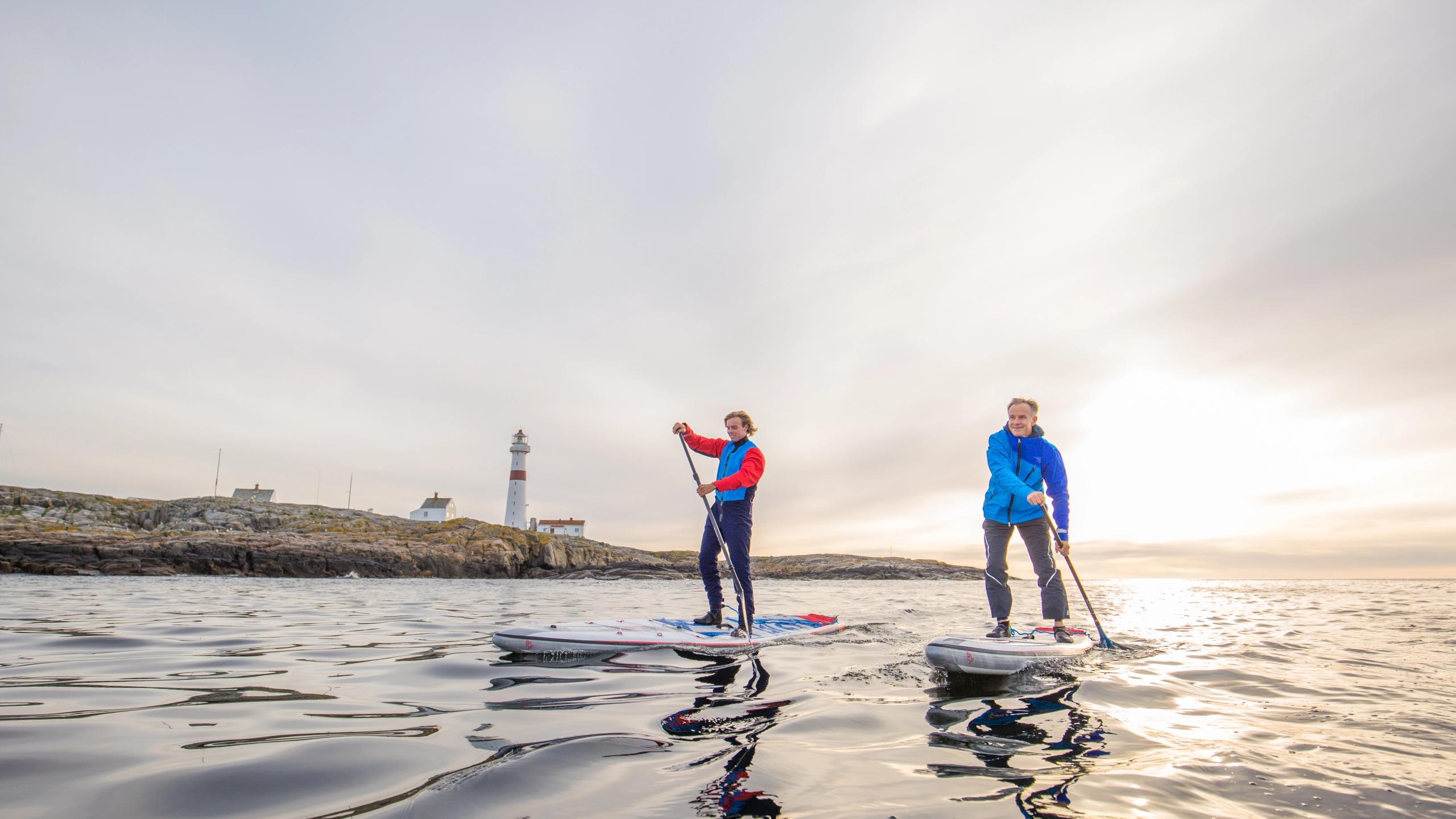 To mennesker på SUP rundt ved Torungen fyr utenfor Arendal på Sørlandet.