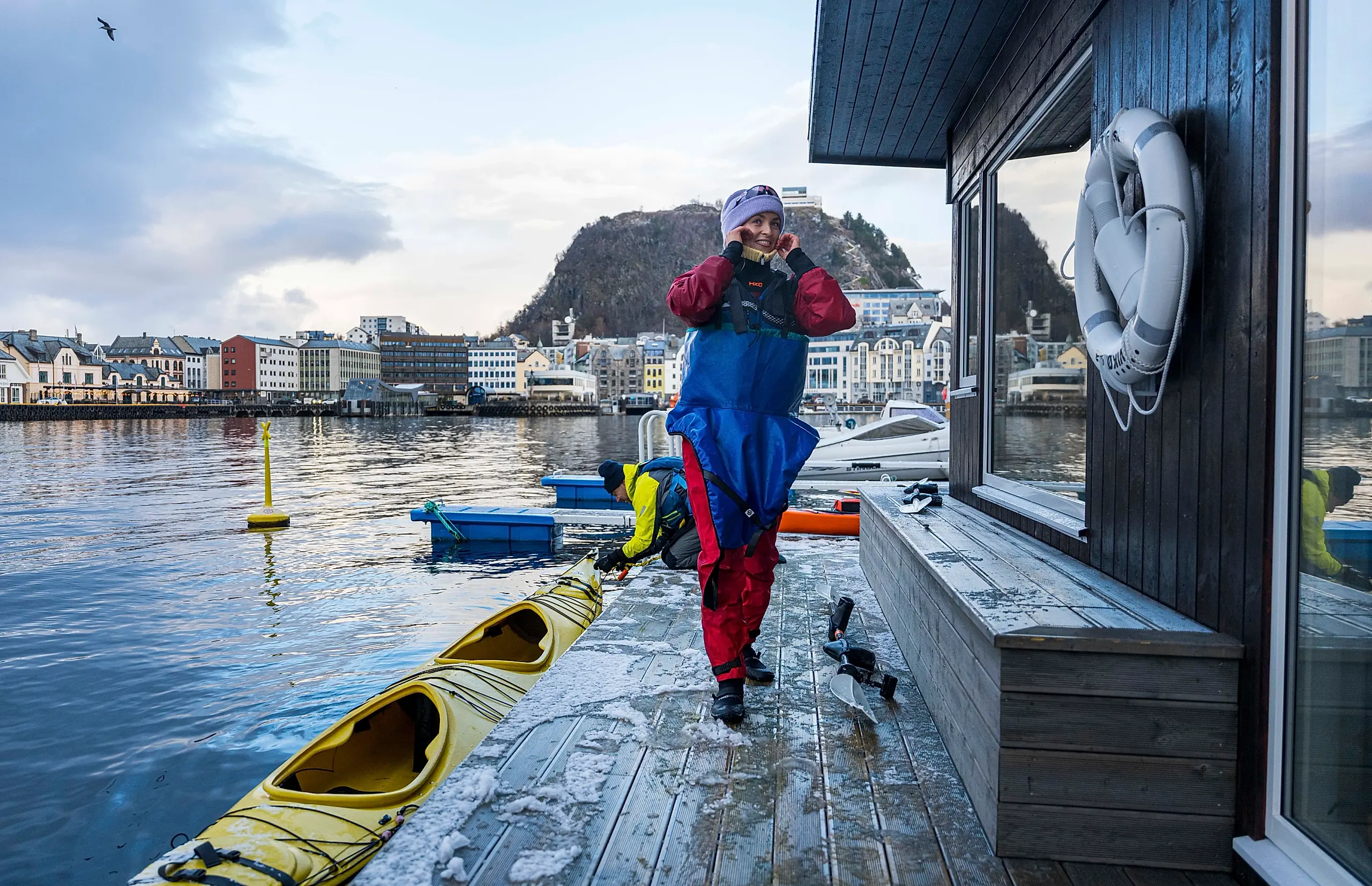 Kvinne går opp fra kajakk til badstue for å bade, i Ålesund