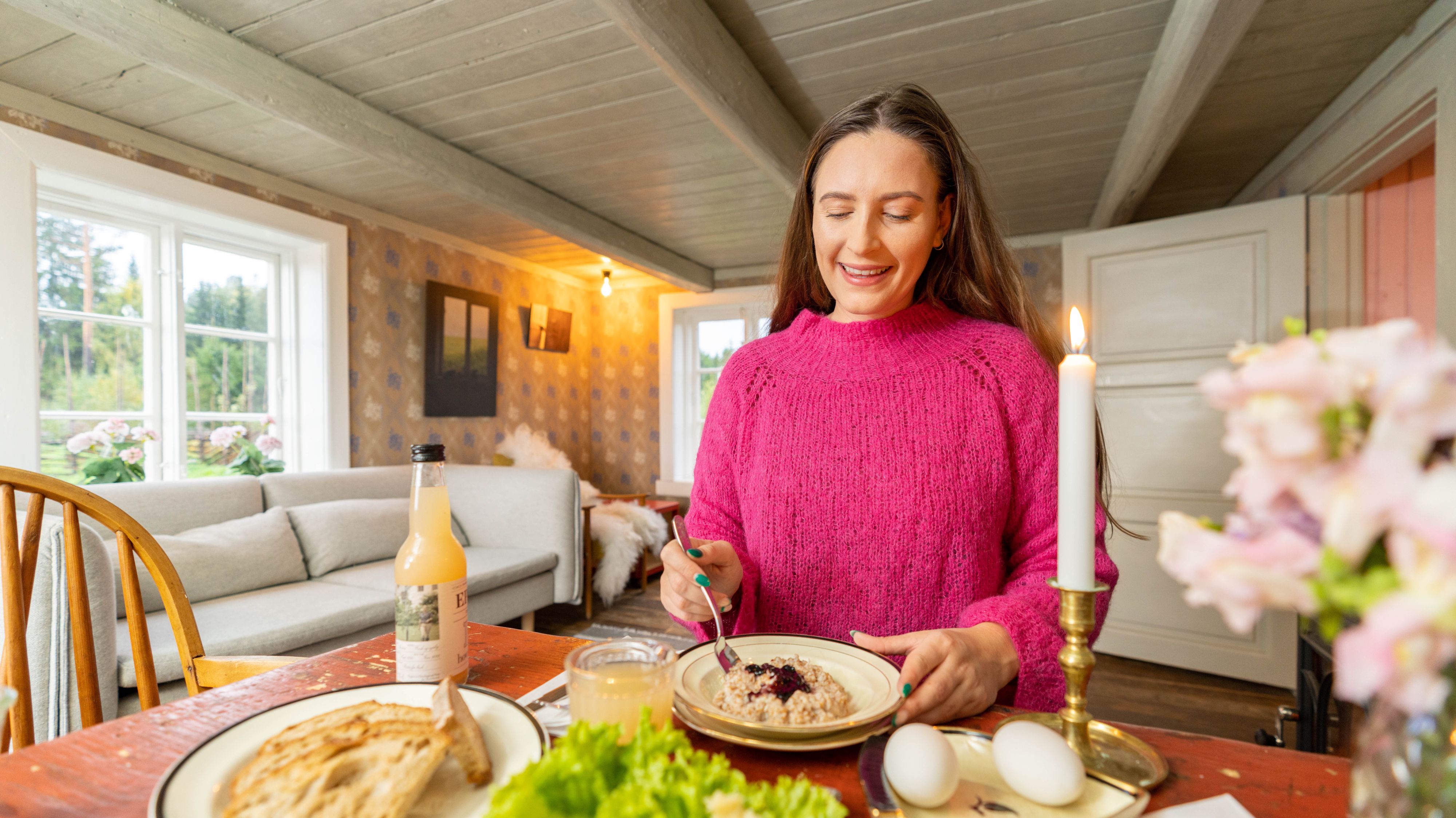 En kvinne spiser frokost i Villa Leonore på Hovelsrud gård, Østlandet, Norge.