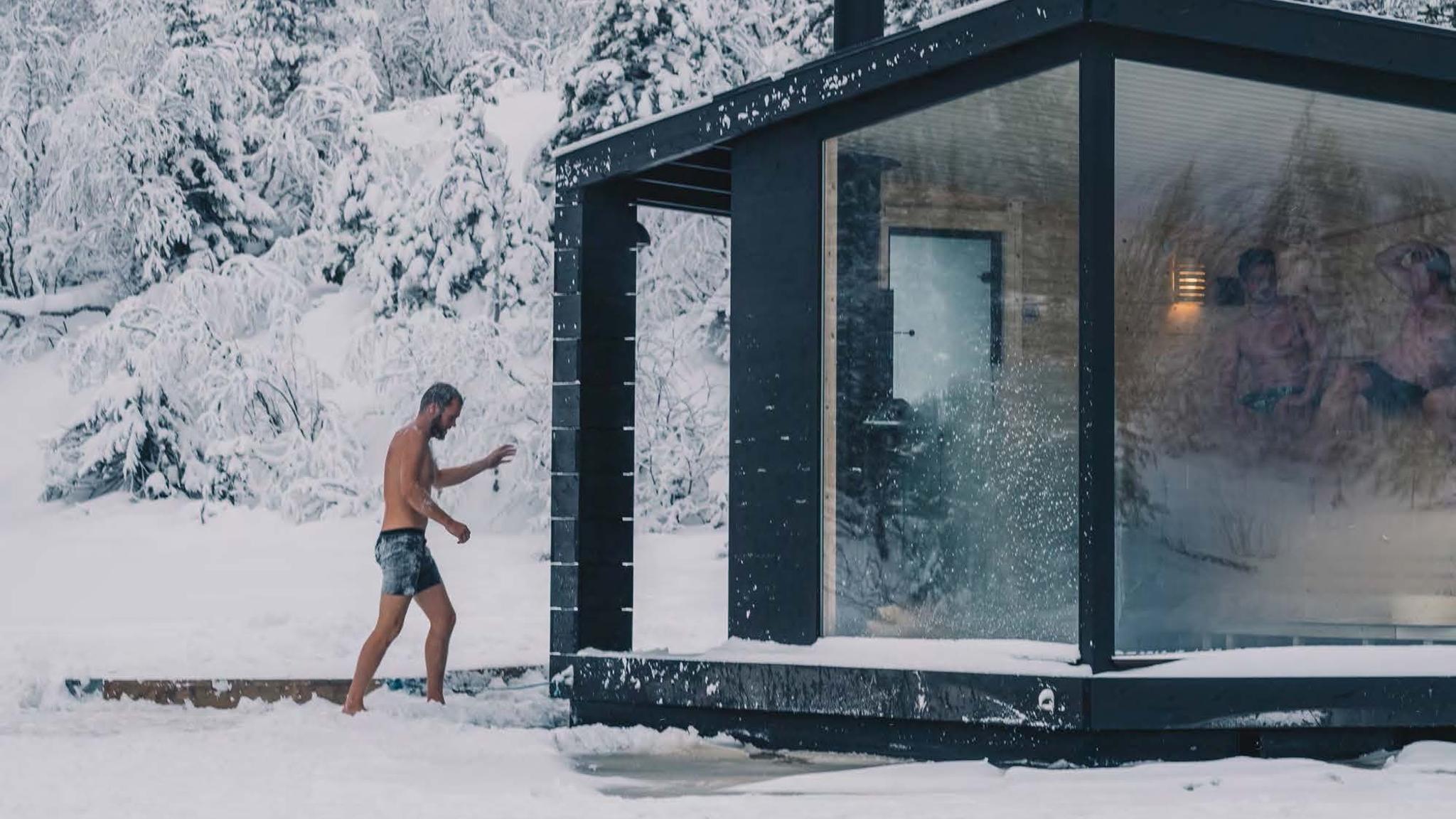 En person er på vei inn i en flytende badstue en vinterdag på Rjukan i Telemark på Østlandet