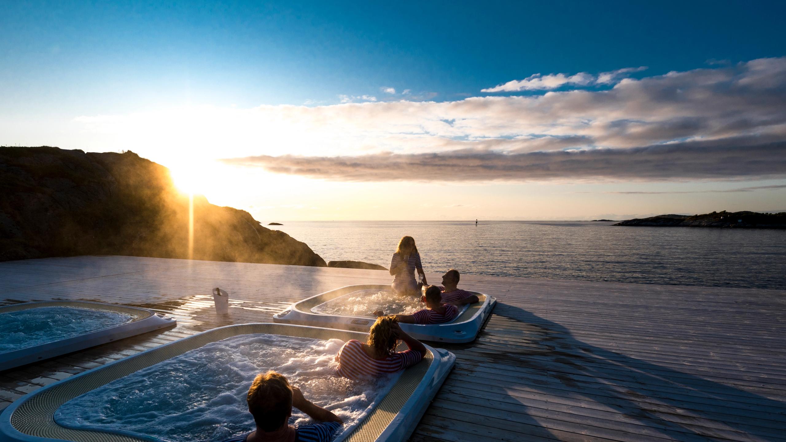 En gruppe mennesker slapper av i jacuzziene i Hamn i Senja