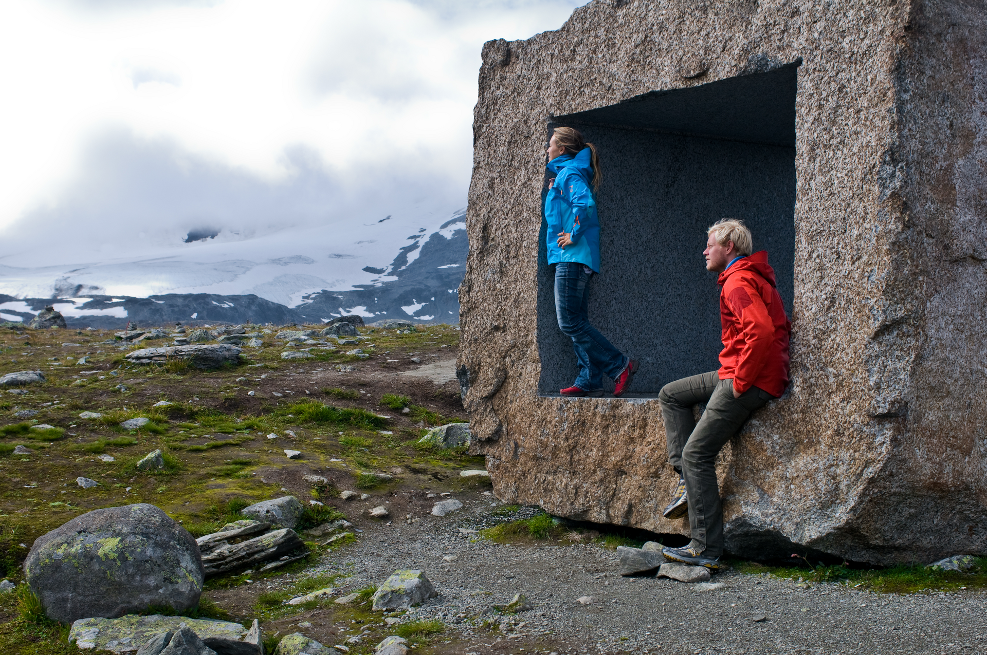 Two people posing at the Mefjellet stone scuplture